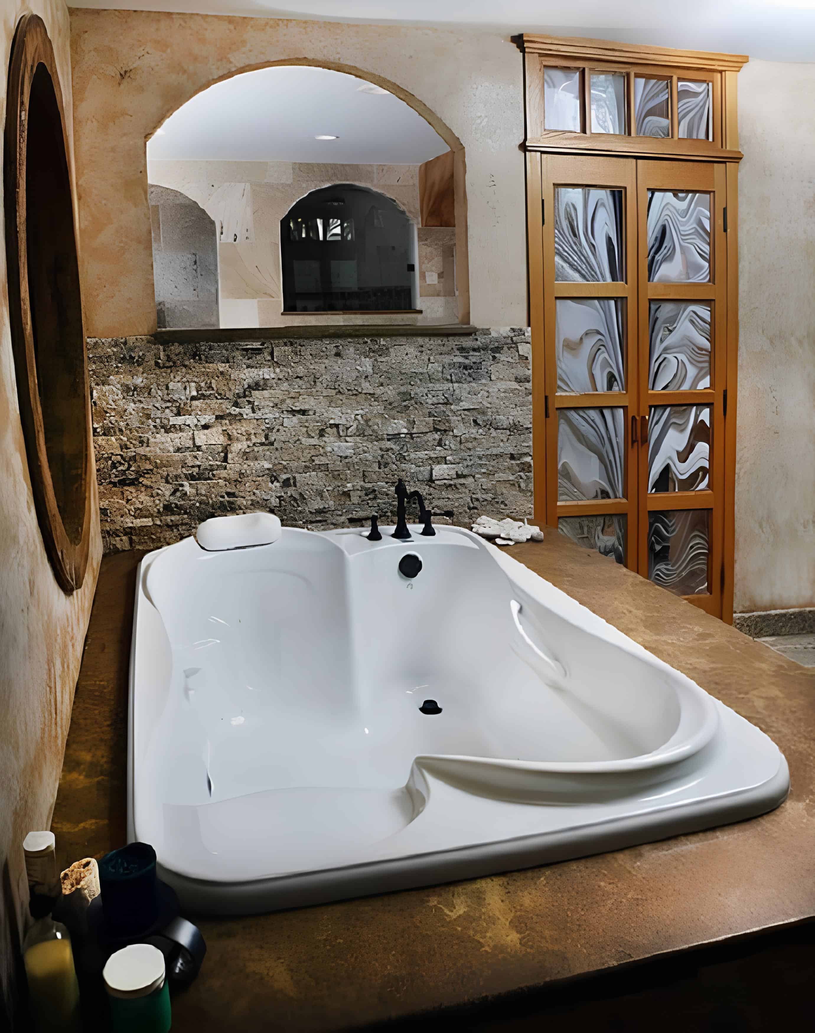 Rustic Indoor Bathtub with Arched Mirror Rustic indoor bathroom with freestanding sculptural bathtub and arched mirror
