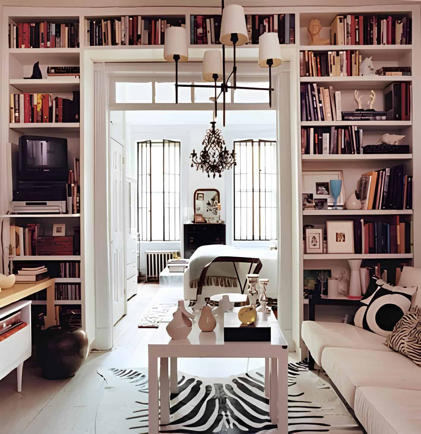 Apartment living room with built-in bookshelves framing doorway to bedroom