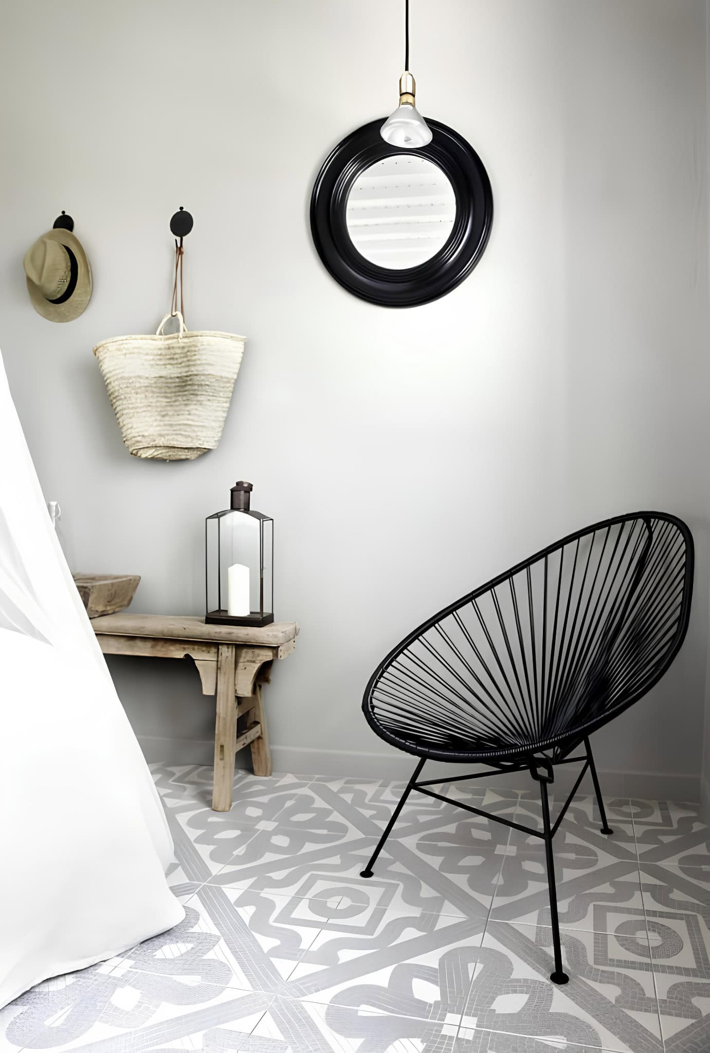 Black Acapulco Chair Patterned Tile Floor Boho chic corner with black Acapulco chair and patterned tile flooring.