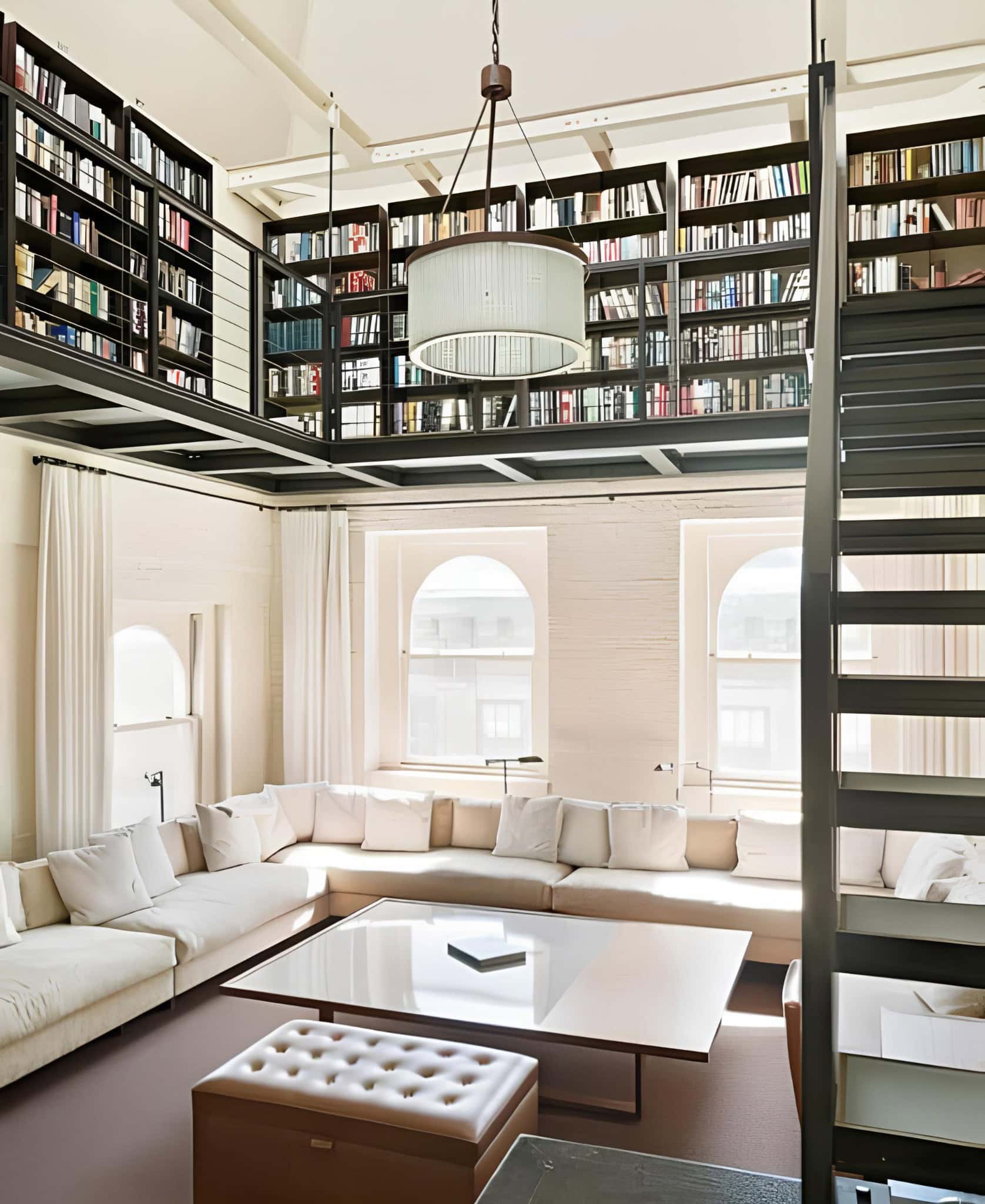 Bright loft home library with sectional sofa and high bookshelves