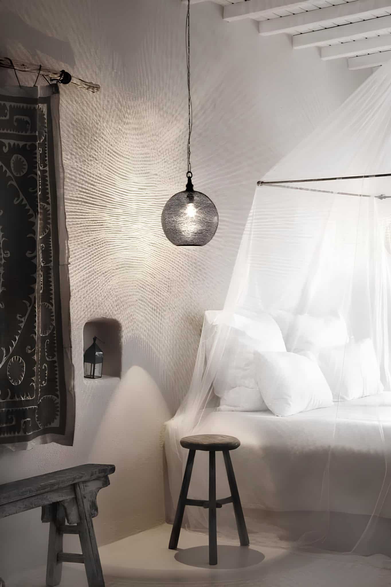 Canopy Bed Ethnic Textile Wall Light Cozy canopy bed with ethnic textile backdrop and soft hanging light.