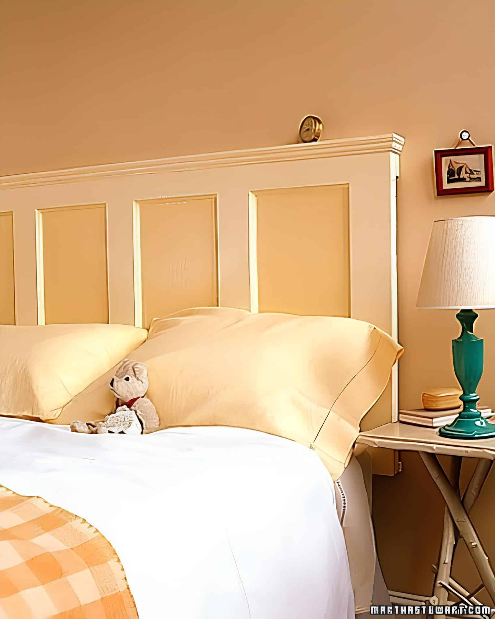 Traditional wood panel headboard in a warm yellow-painted bedroom