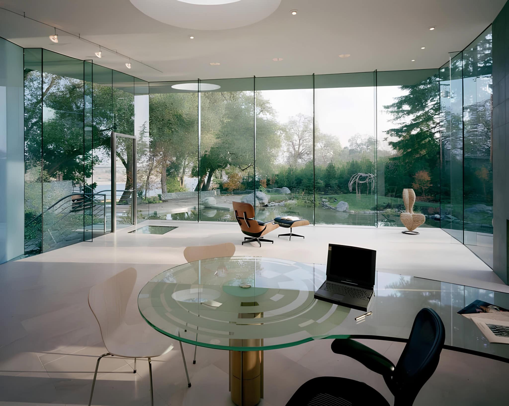 Glass Office Interior Nature Backdrop Interior workspace with panoramic glass walls overlooking lush greenery.