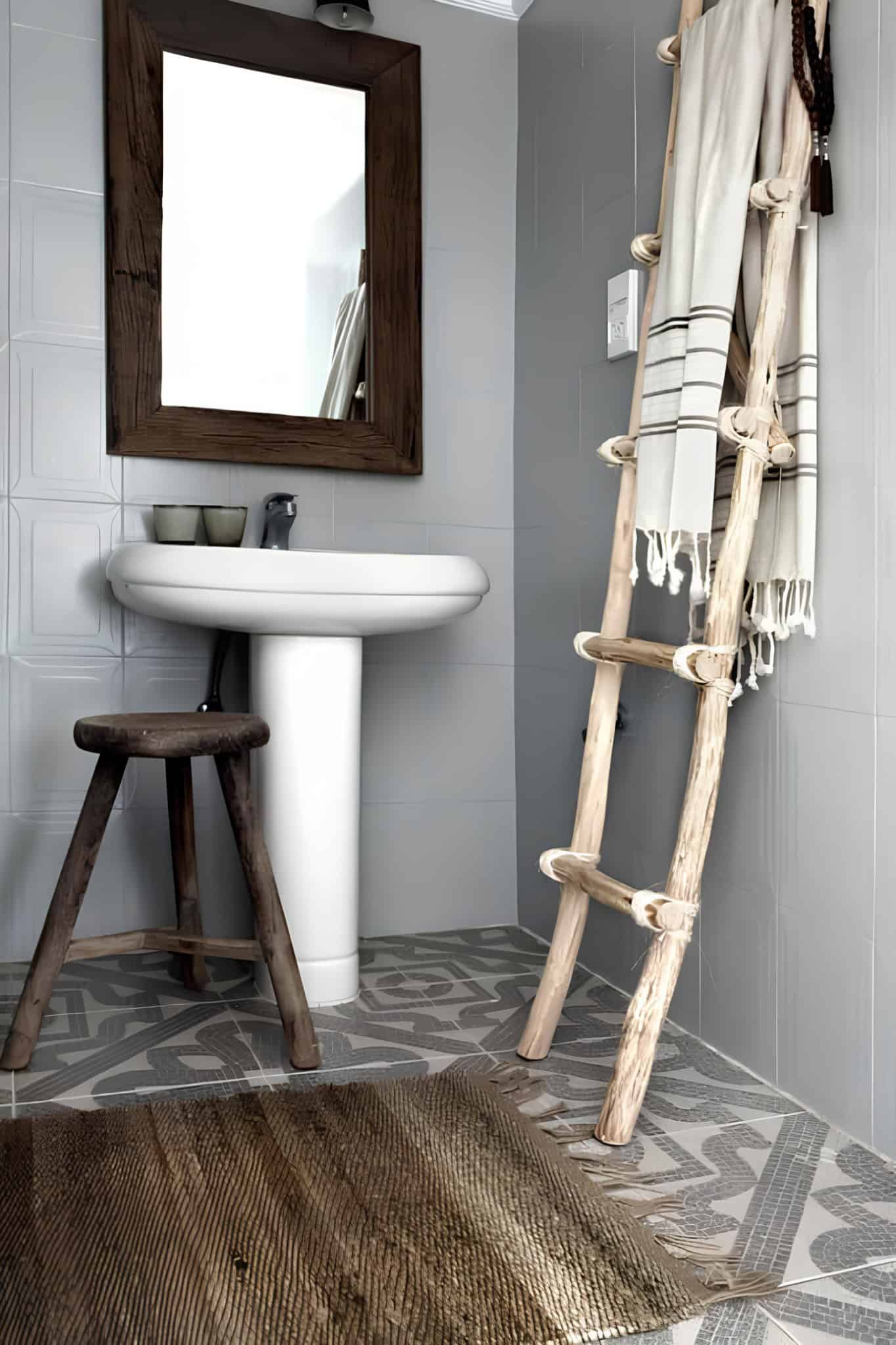 Gray Tile Bathroom Wooden Ladder Decor Gray tiled bathroom featuring a rustic wooden ladder and stool.