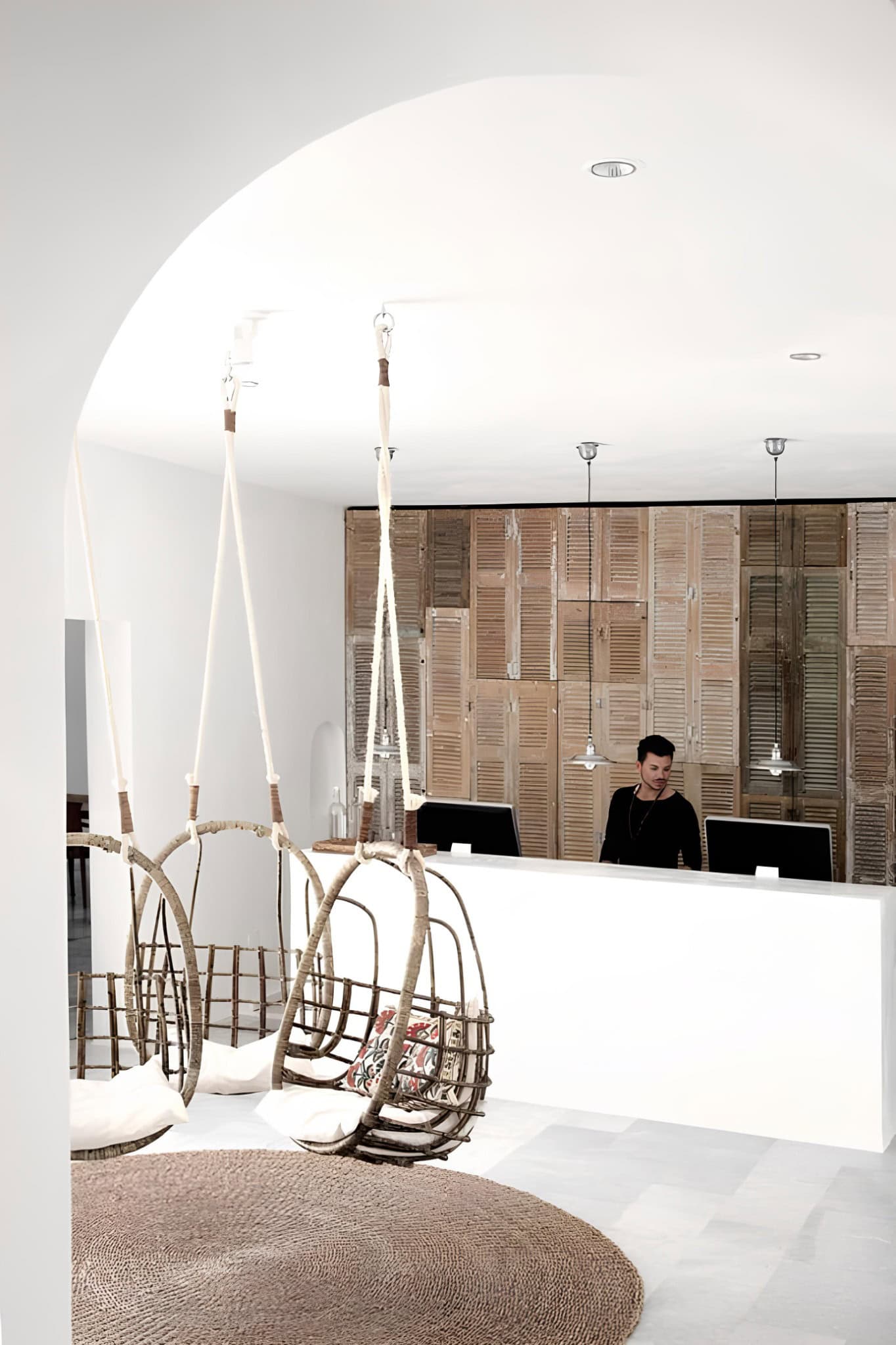 Hotel Reception Wood Panel Wall Swings Minimalist hotel reception with hanging chairs and wood panel feature wall.