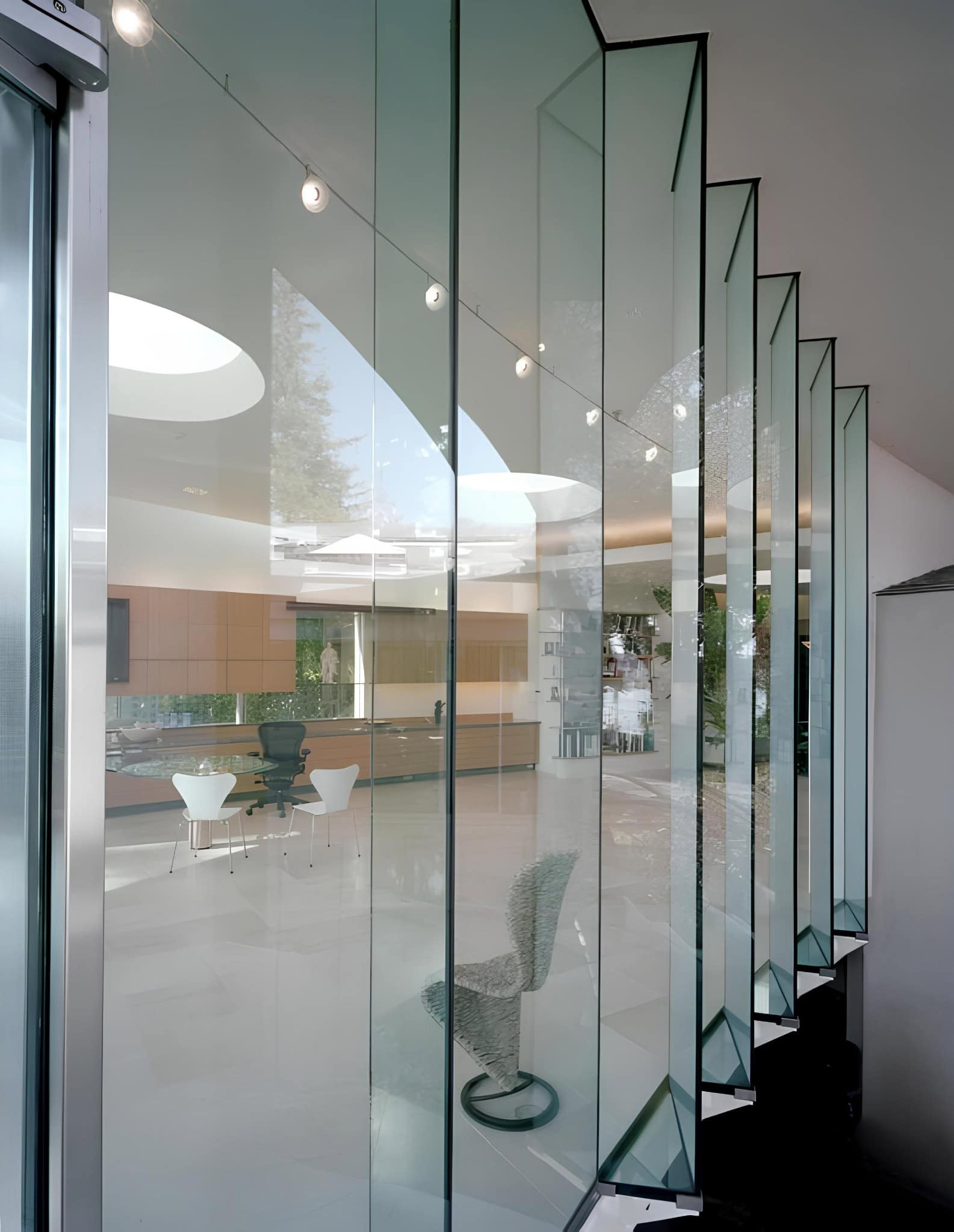 Interior Glass Facade Reflection Detail View through sculptural folded glass facade showcasing modern interior design.