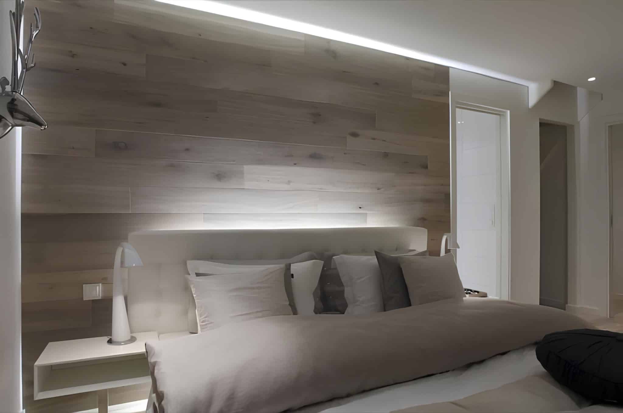 Minimalist bedroom featuring sleek lighting and wood wall panels