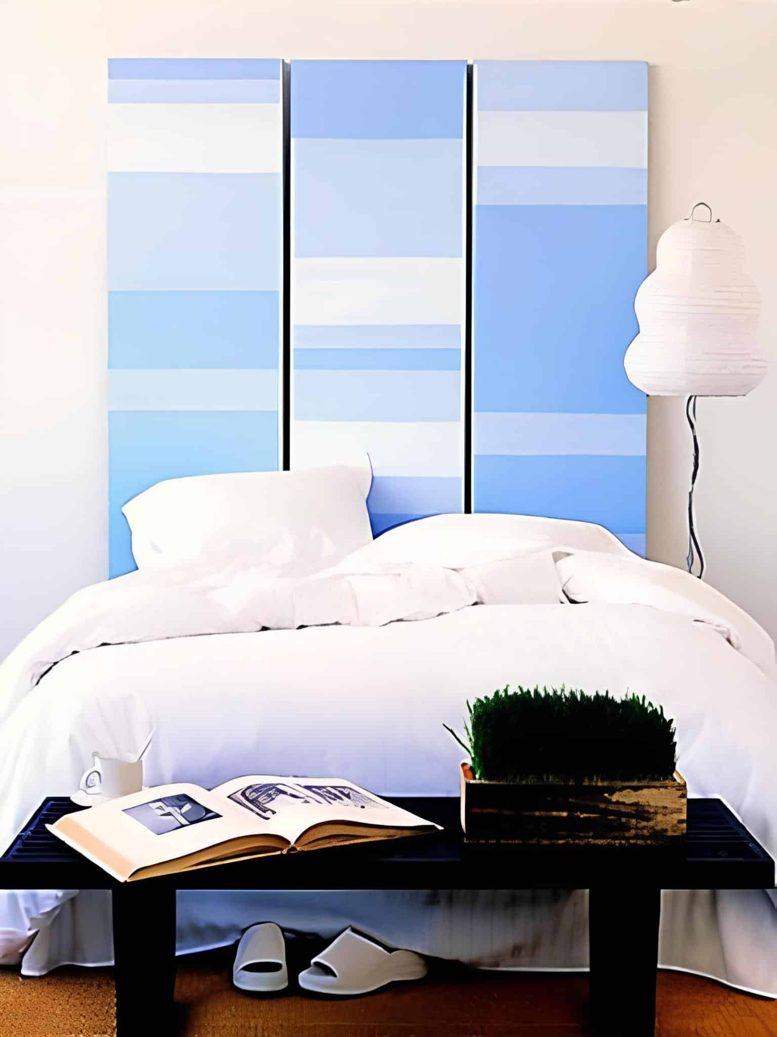 Vertical blue and white striped panels behind minimalist bed