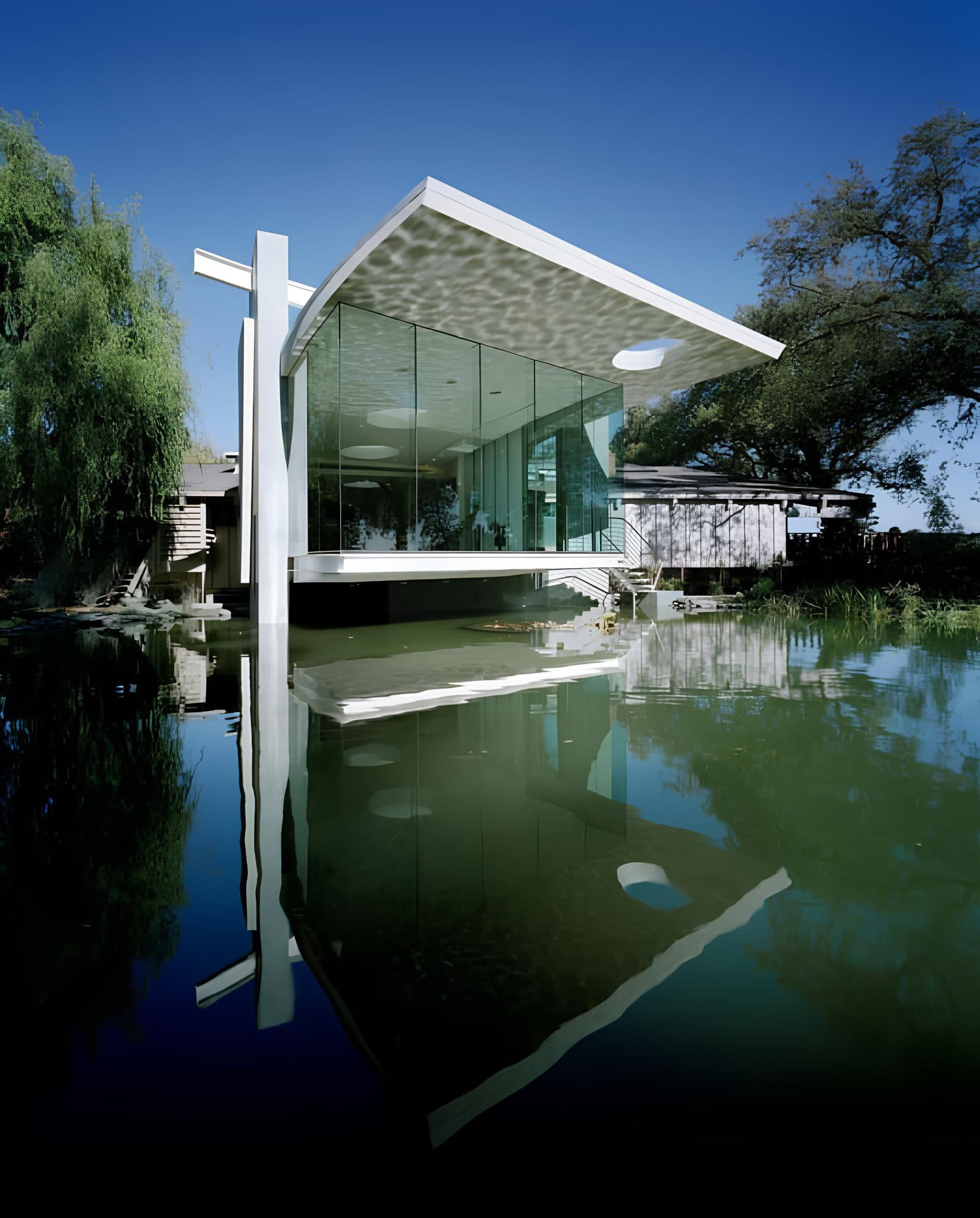 Modern Lakeside Studio Glass Architecture Contemporary lakeside studio with cantilevered glass facade reflecting in water.