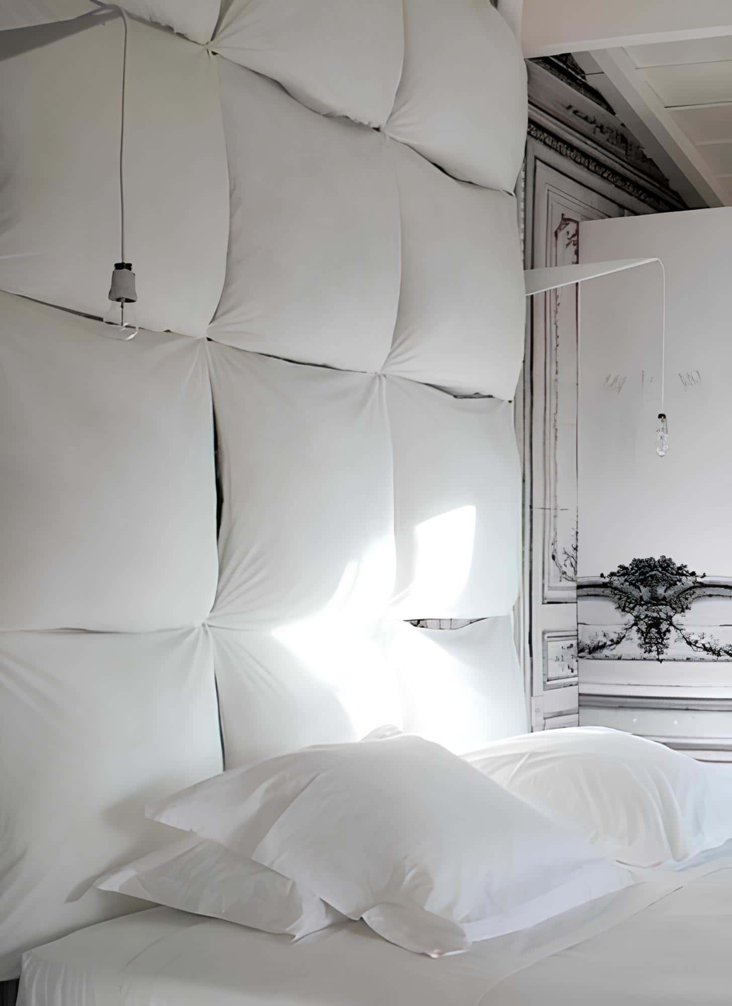 Wall-mounted oversized cushions create a dramatic headboard effect