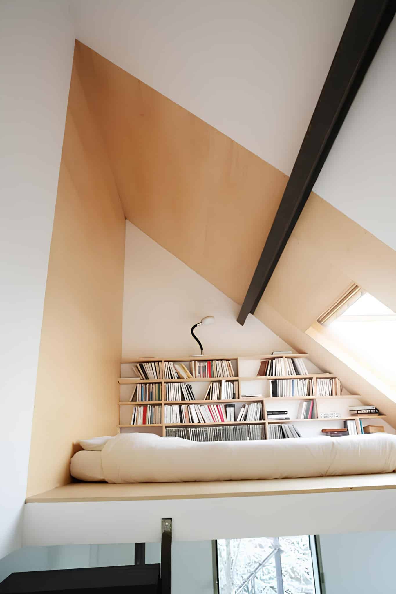 Small loft-bed home library nook with sloped ceiling and bookshelves