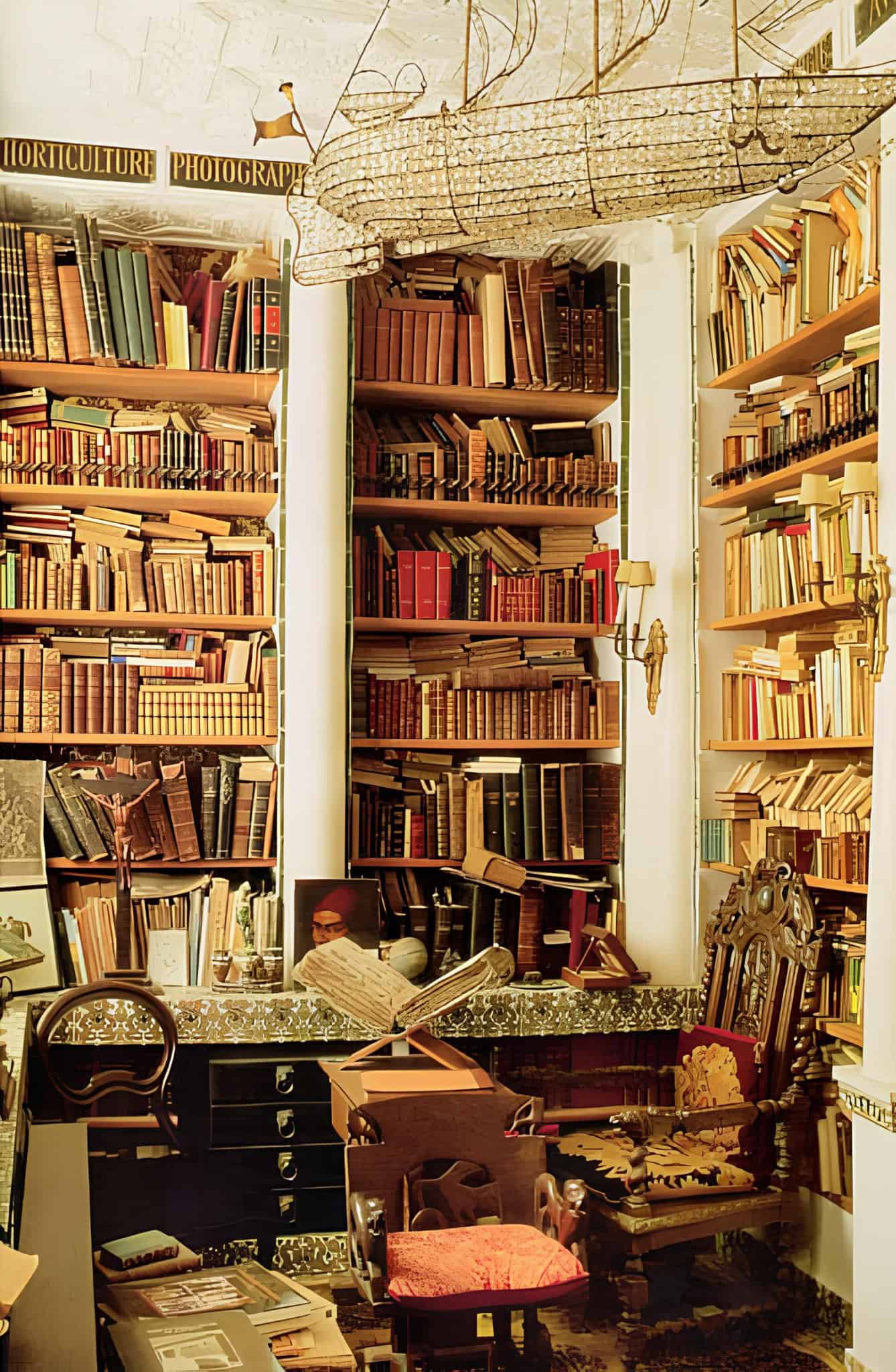 Vintage eclectic home library filled with books, antique desk and ornate chair