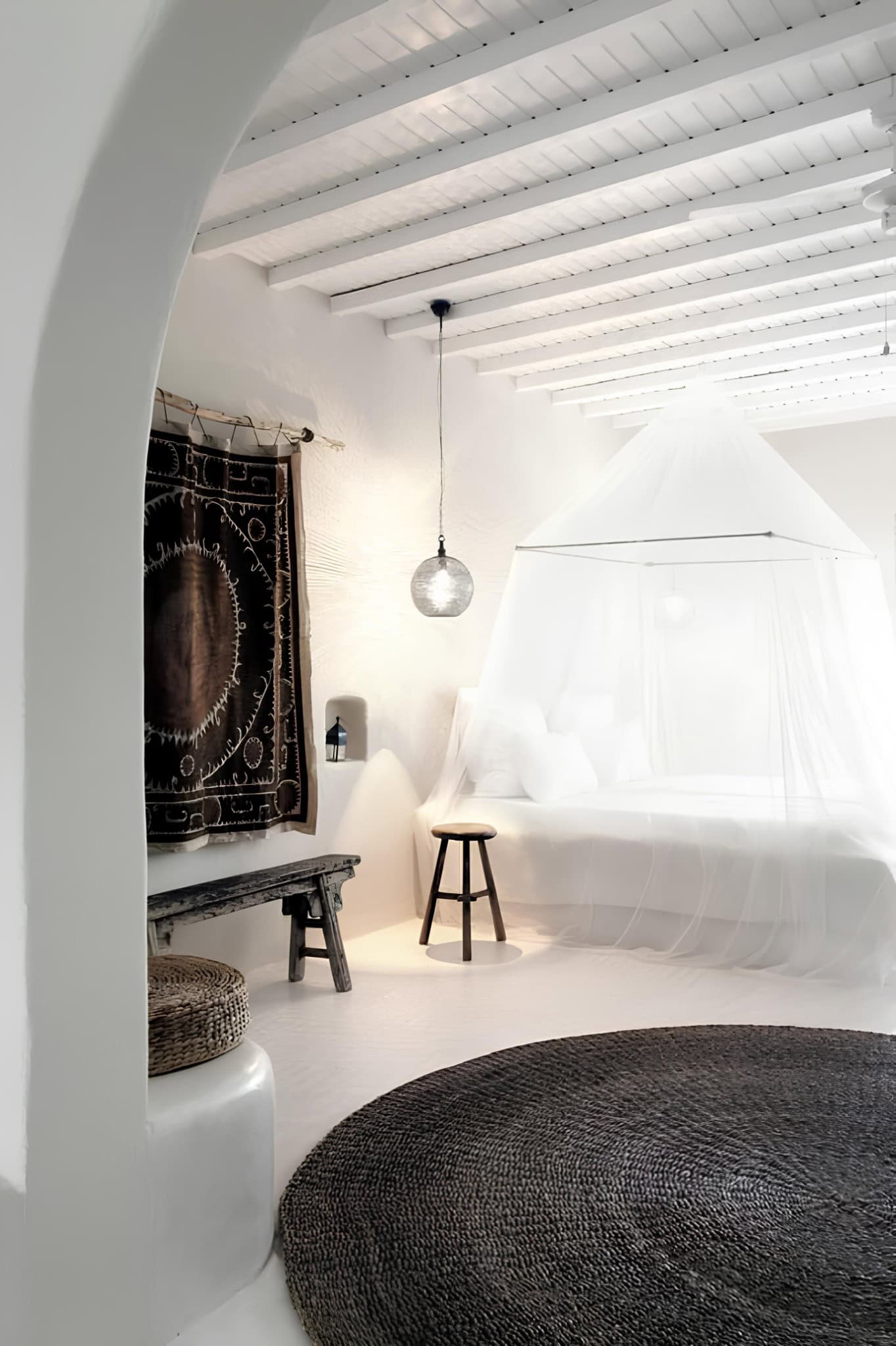 White Canopy Bed Ethnic Textiles Decor White bedroom with canopy bed, hanging pendant light, and ethnic wall textile.