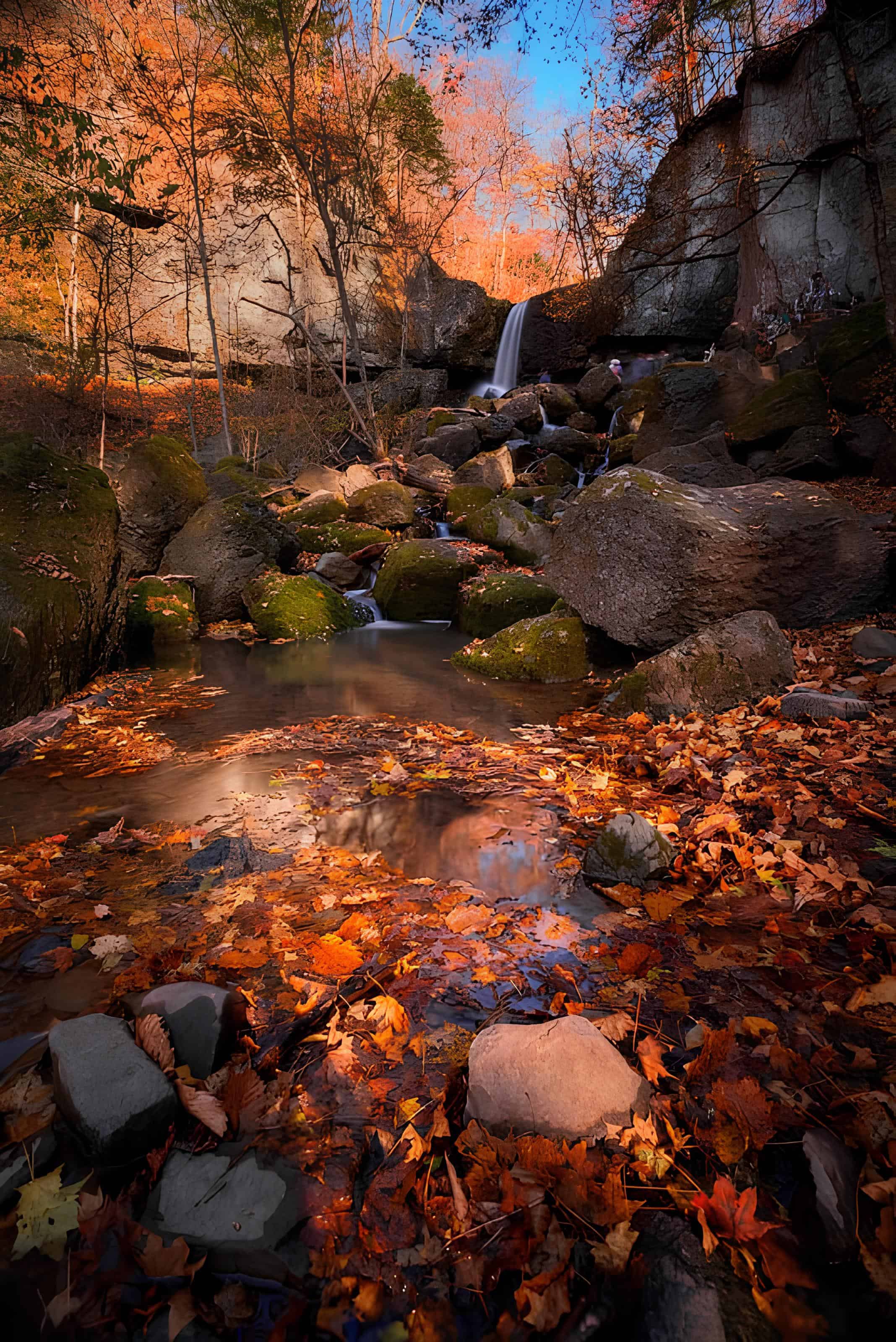Autumn Falls in Rocky Glen Waterfall flowing through colorful autumn leaves and rocky outcrops