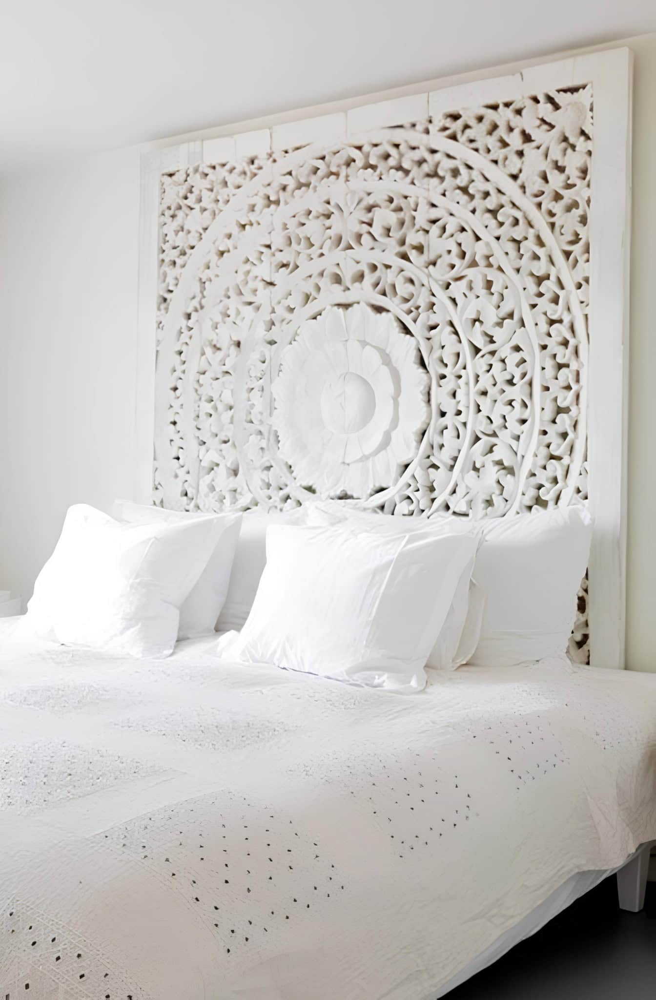 Boho White Bedroom with Carved Headboard White bohemian bedroom with ornate carved headboard and white bedding