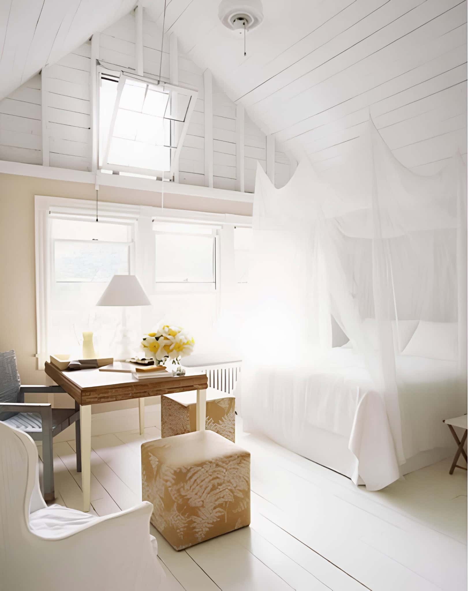 Bright Loft Bedroom with Mosquito Net Canopy Loft-style white bedroom with exposed ceiling beams and canopy bed