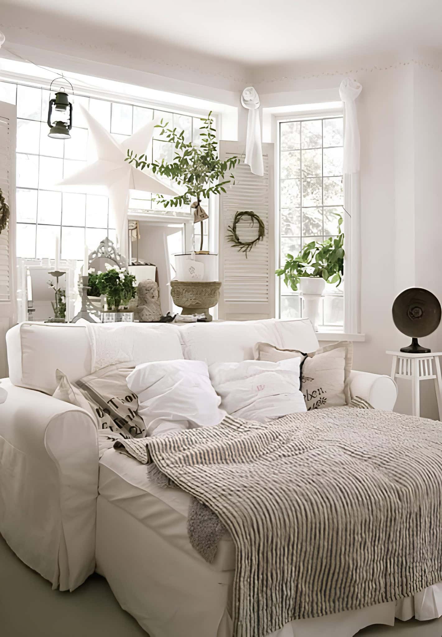 Cozy White Bedroom with Potted Plants Rustic cozy white room with lots of greenery, soft linens and natural light