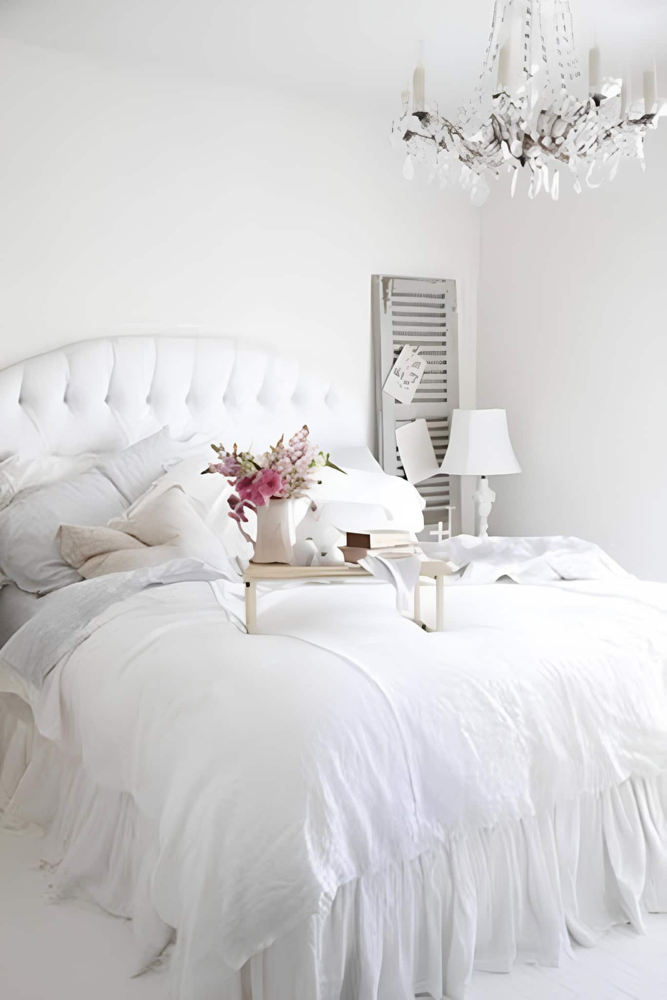 Elegant White Bedroom with Breakfast Tray Plush white bed with tufted headboard and tray with breakfast and flowers