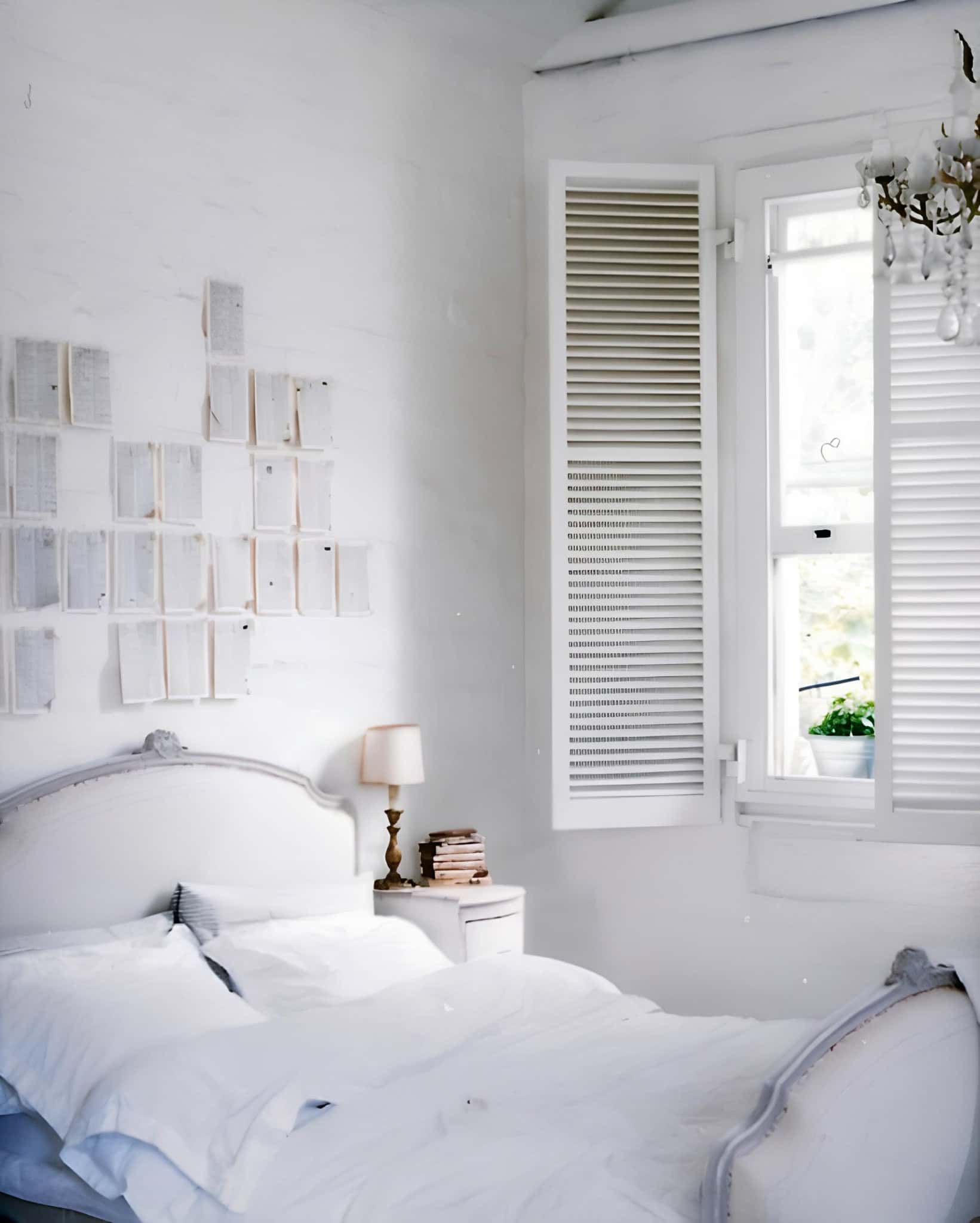 French-Inspired White Bedroom with Shutters French-inspired white bedroom with louvered window shutters and wall art