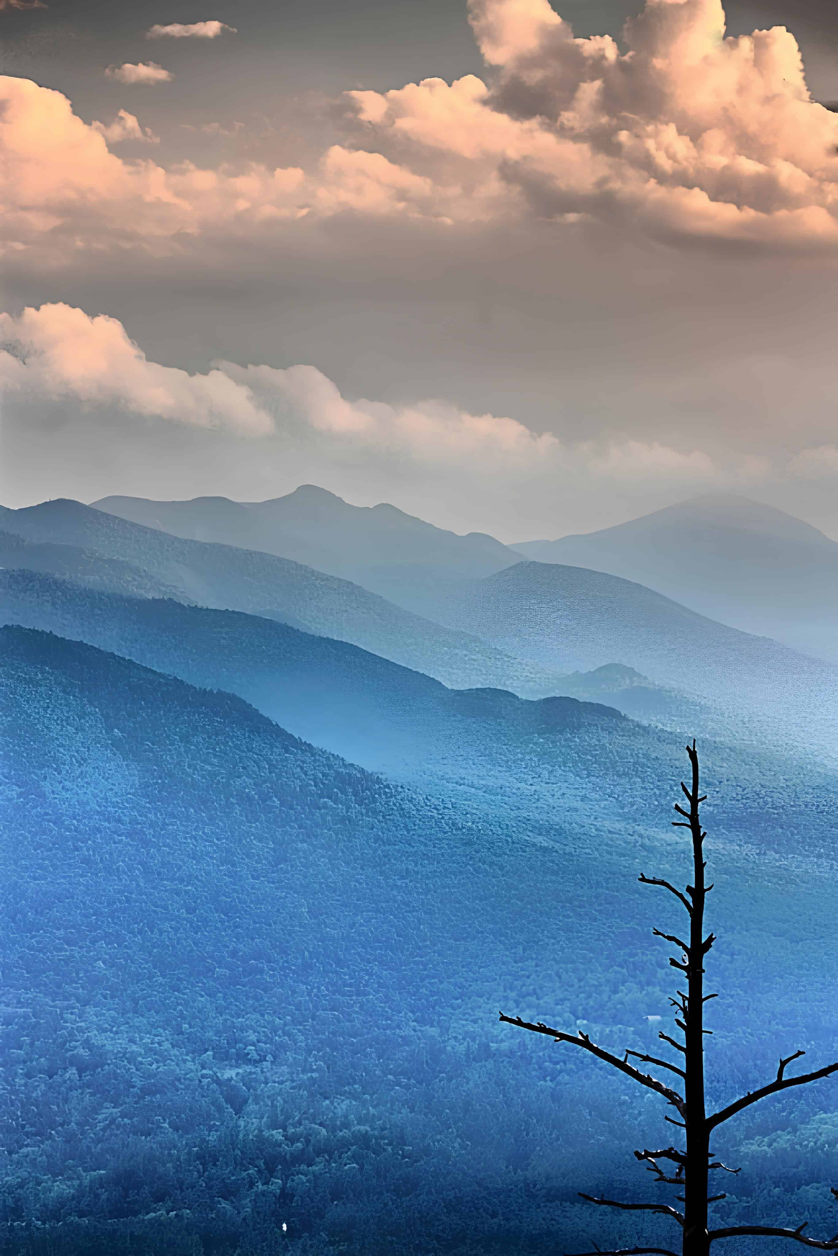 Layers of Blue Mountains Multiple mountain ridges fading into the horizon under dramatic clouds