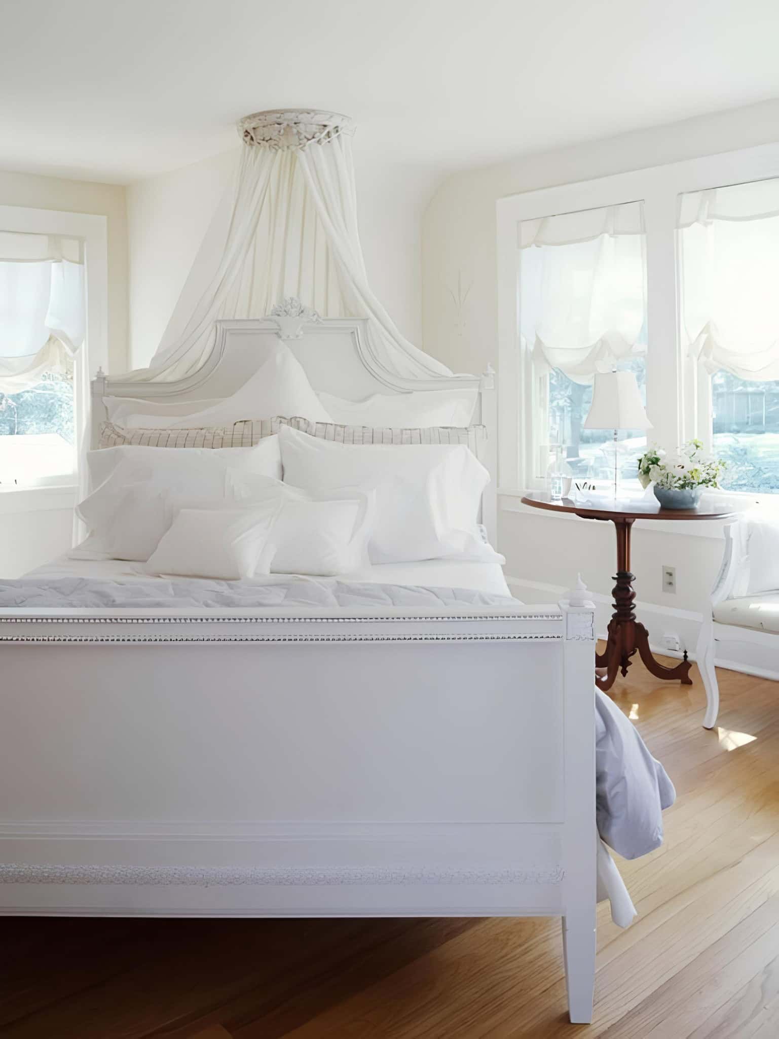 Romantic White Bedroom with Canopy and Pillows Bright bedroom with white canopy over bed and soft pillow arrangements