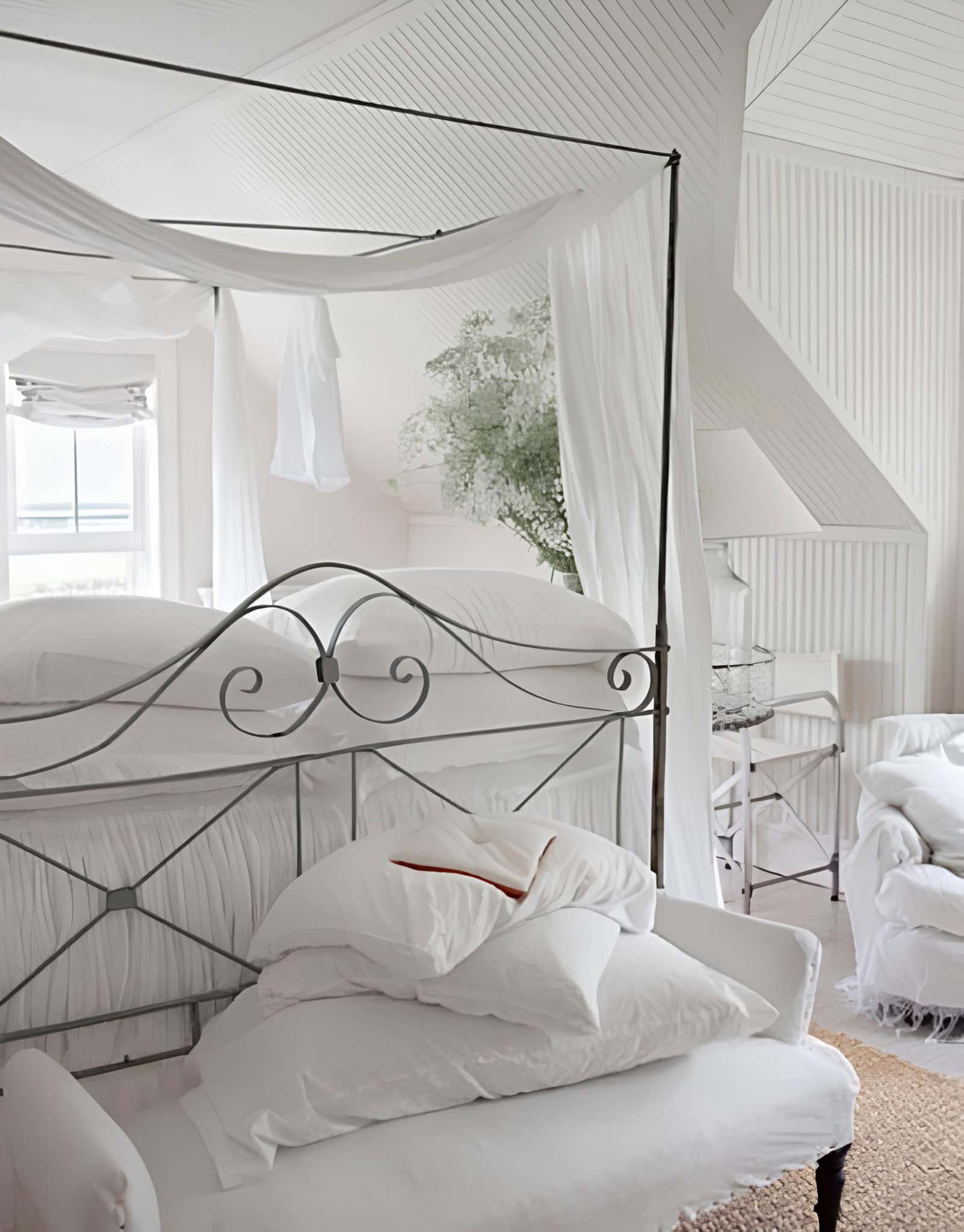 Romantic White Canopy Bedroom with Metal Frame White canopy bed with metal frame and layered pillows in romantic decor