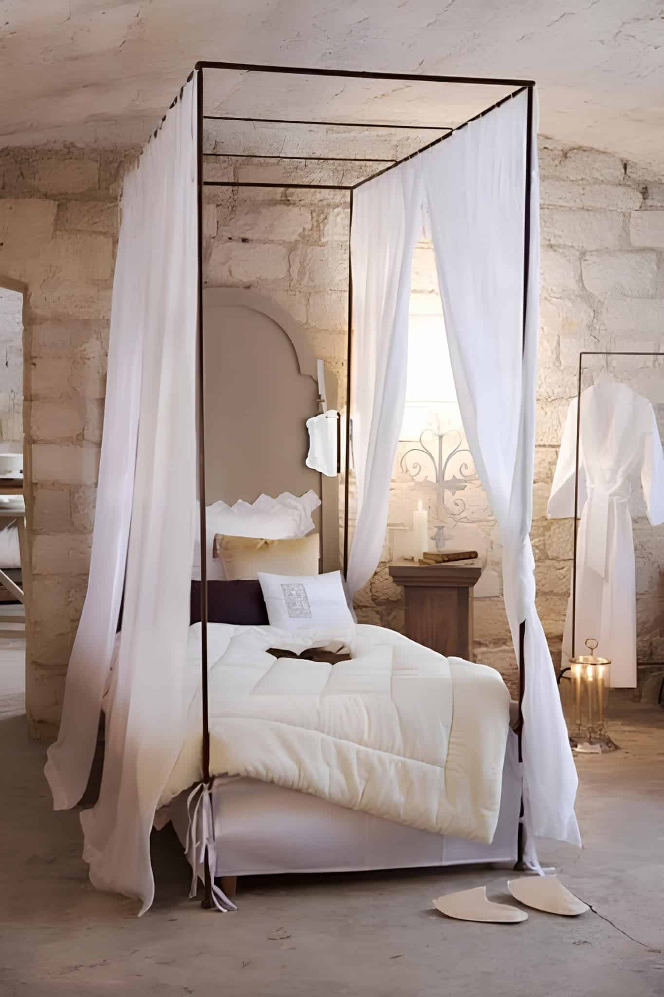 Rustic Canopy Bedroom with Stone Walls Rustic bedroom with stone walls, sheer canopy bed, and cozy lighting