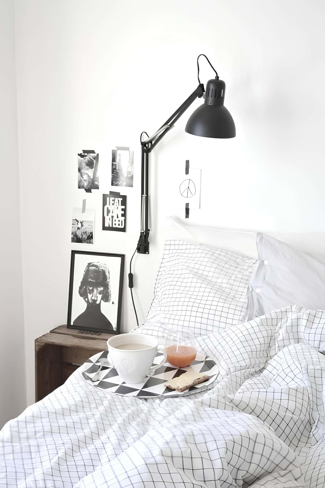 Scandinavian Bedroom with Breakfast Tray and Graphic Decor Scandi white bedroom with grid bedding, black wall lamp, and breakfast tray