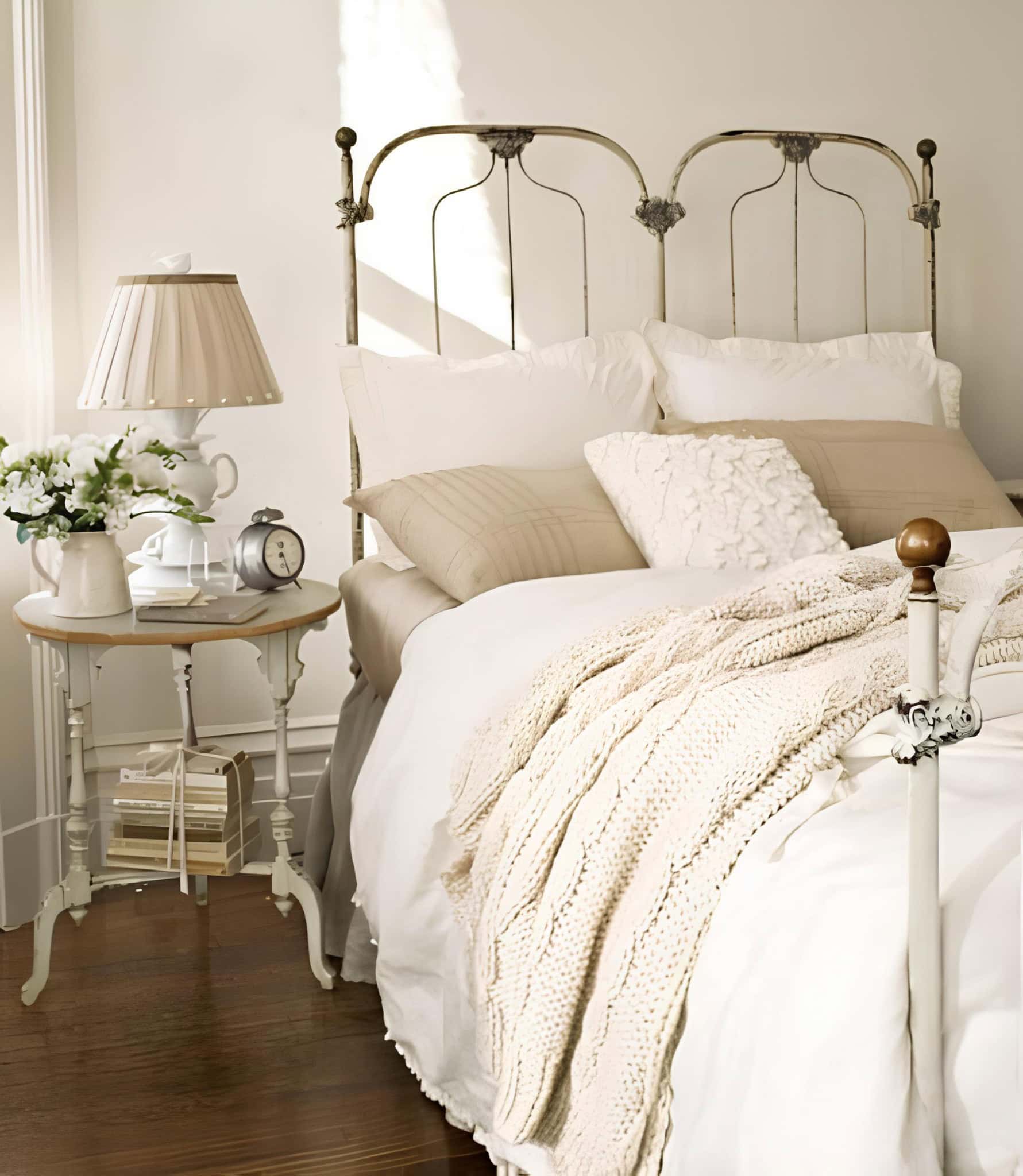 Vintage Style White Bedroom with Metal Bedframe Elegant white room with vintage iron bed, cozy knits and neutral palette