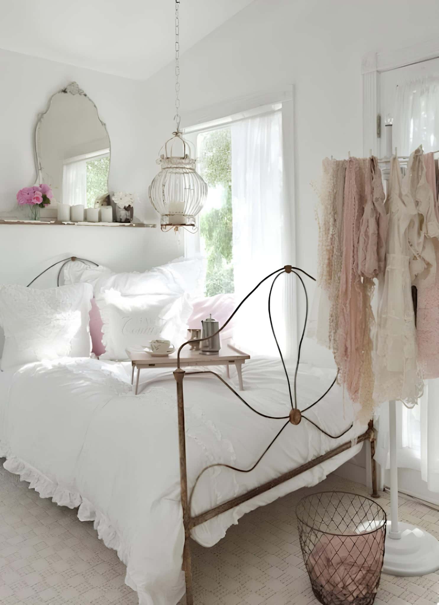 Vintage White Bedroom with Pink Accent Decor Shabby chic bedroom with hanging cage lamp, pink clothes and antique mirror
