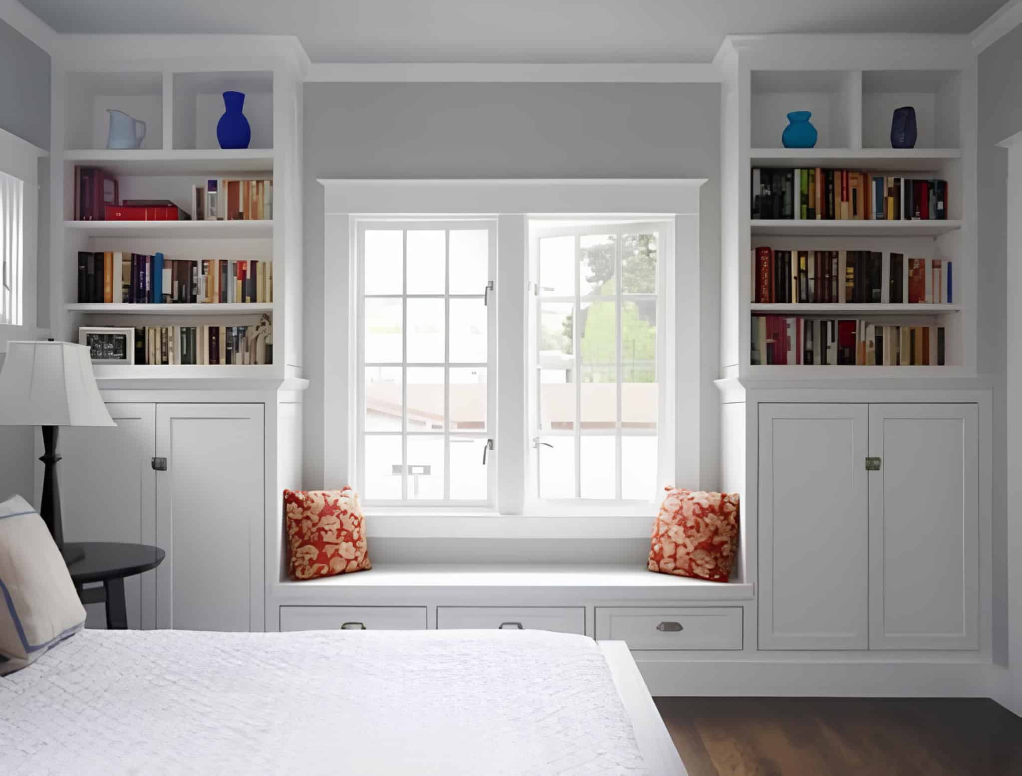 White Bedroom with Built-In Bookcases and Window Seat Classic white bedroom with bookcases and bench seat under window
