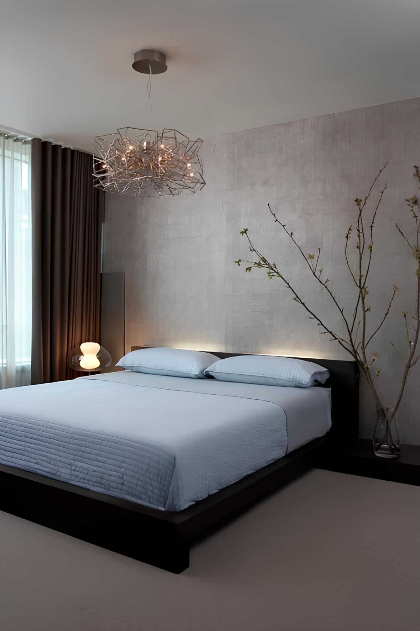 Modern minimalist bedroom with abstract light fixture and clean bedding