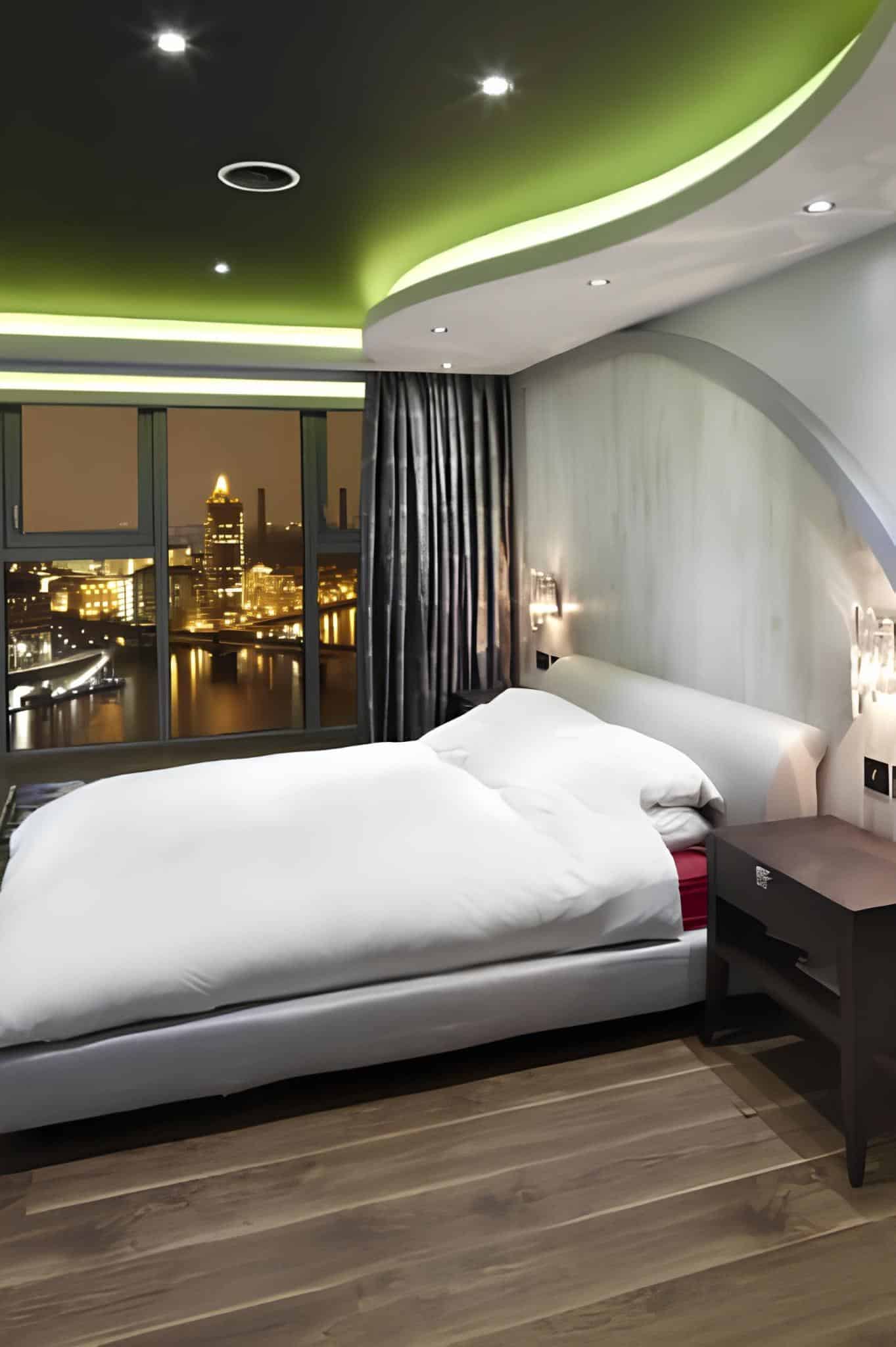 Contemporary bedroom with city lights view and curved ceiling design