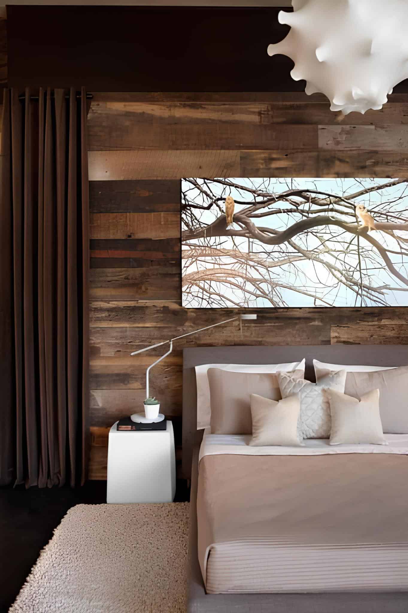 Warm bedroom featuring reclaimed wood wall and soft bedding