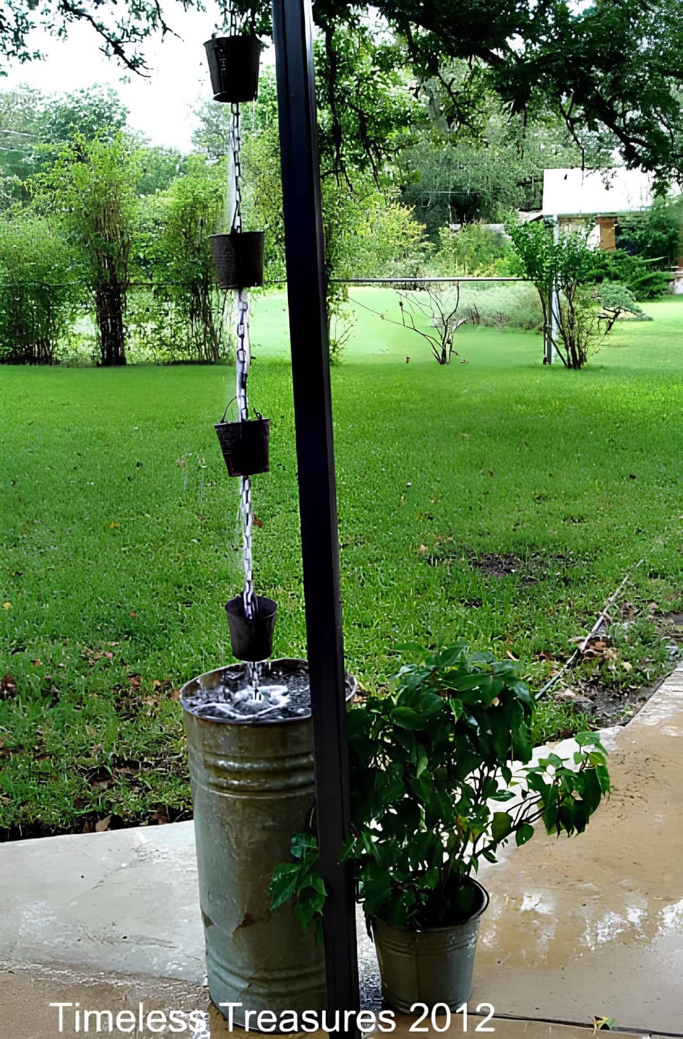 Rainwater flowing down a chain of small rustic buckets into a tall metal barrel