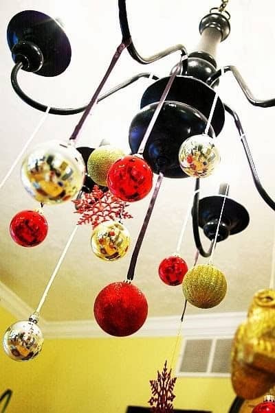 Hang ornaments from a light fixture to transform it into a Christmas chandelier Source