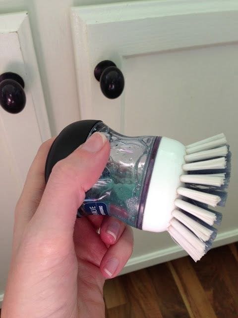 Use a dish scrubber filled with dish soap to clean the gunk off your cabinets 2