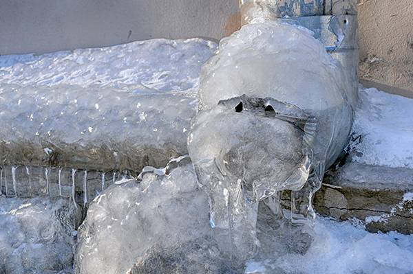 Frozen water in the downspout in the winter in Russia