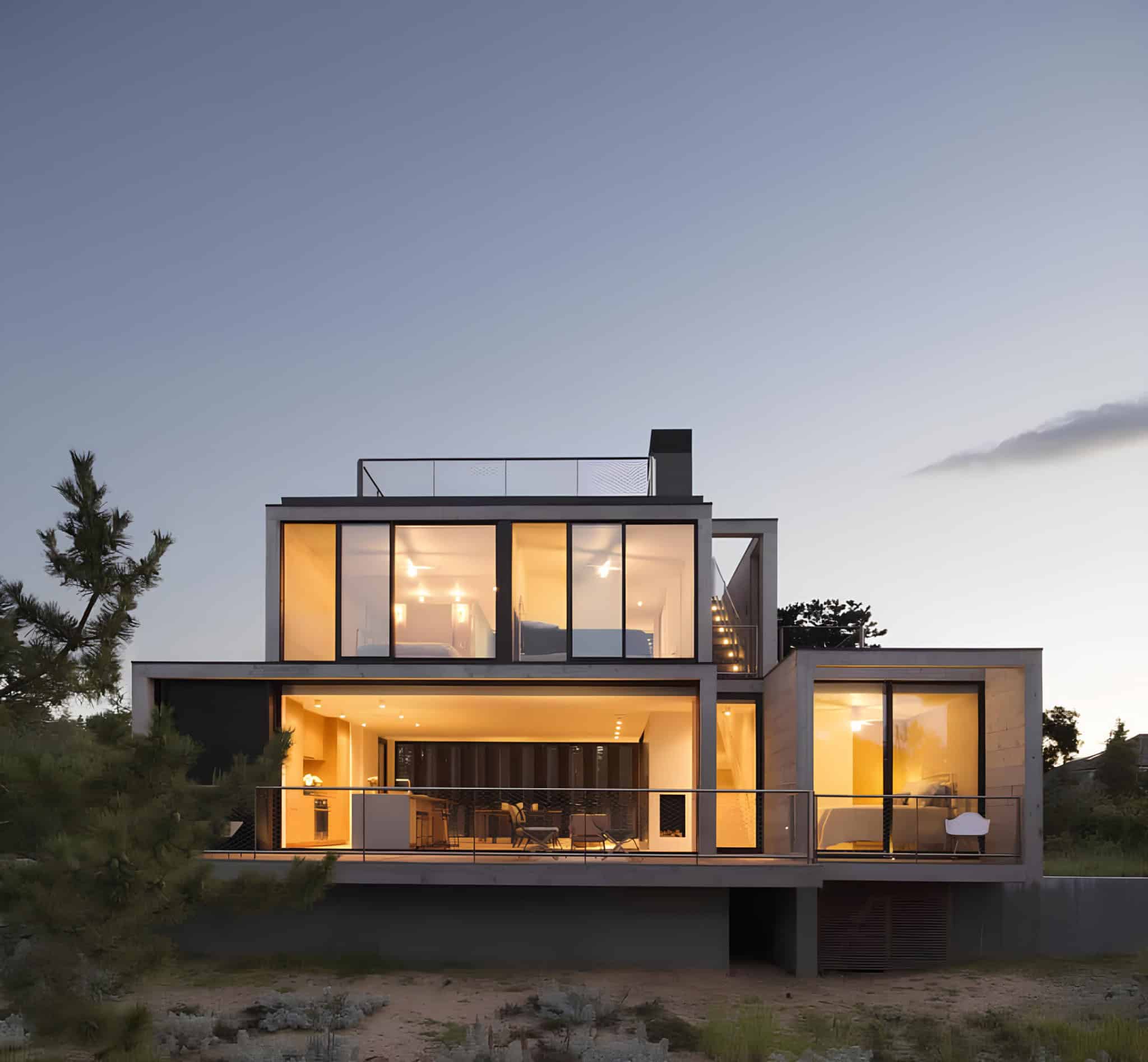 Glowing Interior Night Modern Dunes House Modern house glowing at night with large glass windows.