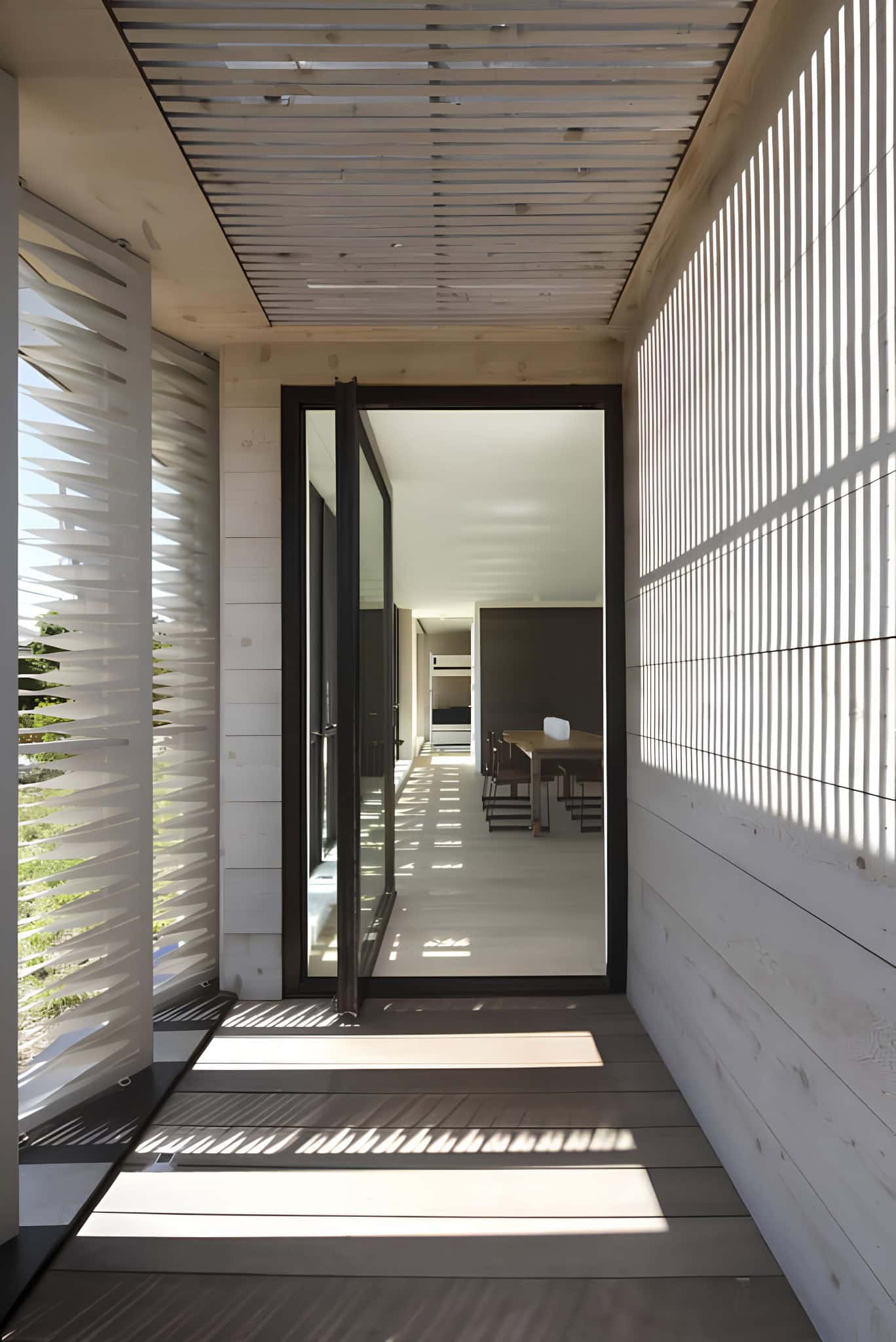 Sunlight Filtered Entryway Wooden Screens Wooden slatted entry with patterned sunlight filtering through.