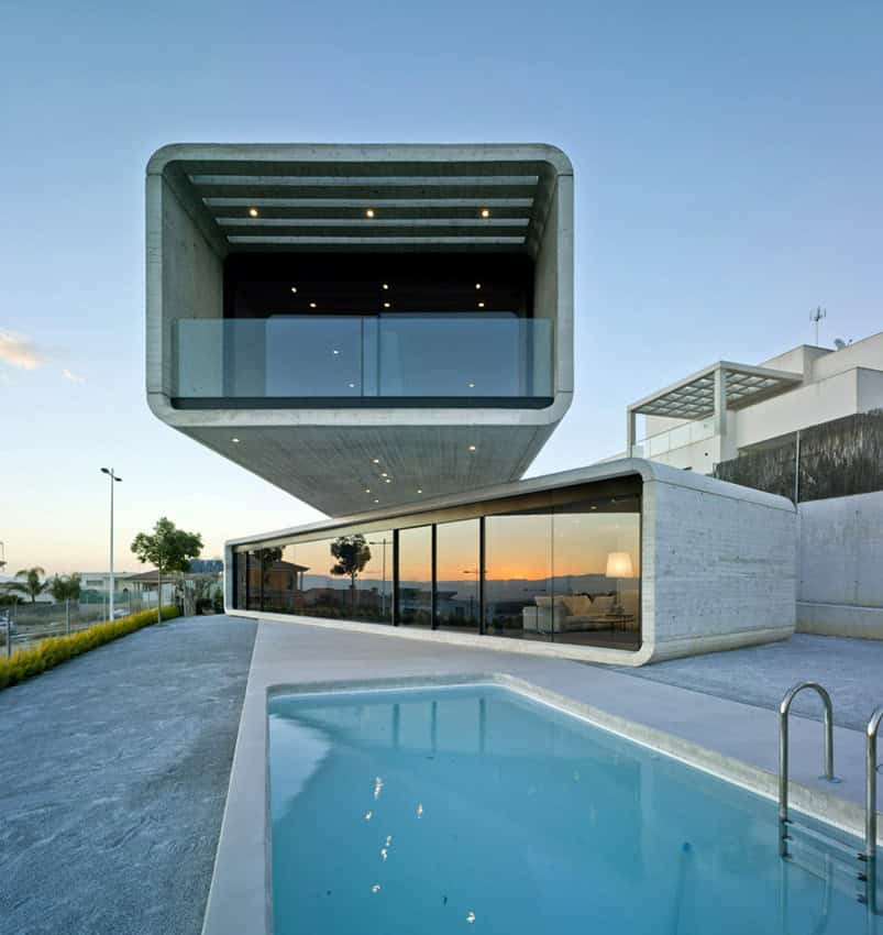 Futuristic modern house with cube-shaped architectural design, large glass windows, and a swimming pool, showcasing innovative contemporary architecture and luxury home design.
