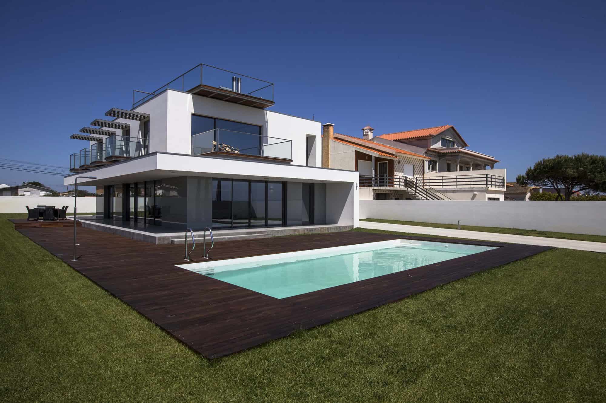 Modern contemporary house with outdoor swimming pool, wooden deck, large glass windows, and minimalist architectural design. Perfect for luxury outdoor living and modern home aesthetics.