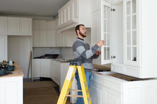 Carpenter installing kitchen cabinet
