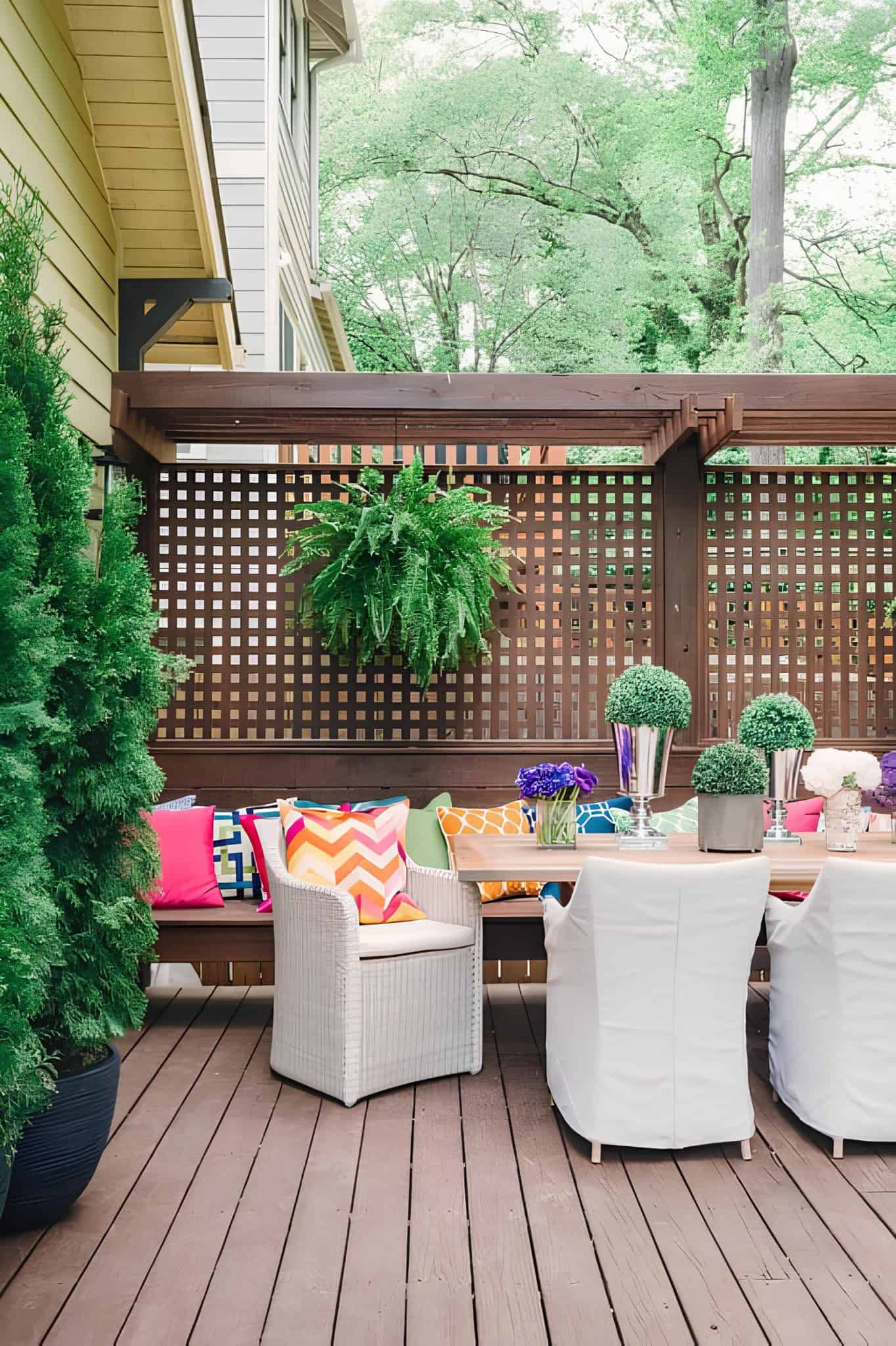 Bright and colorful patio setup with a wood lattice privacy screen and vibrant cushions