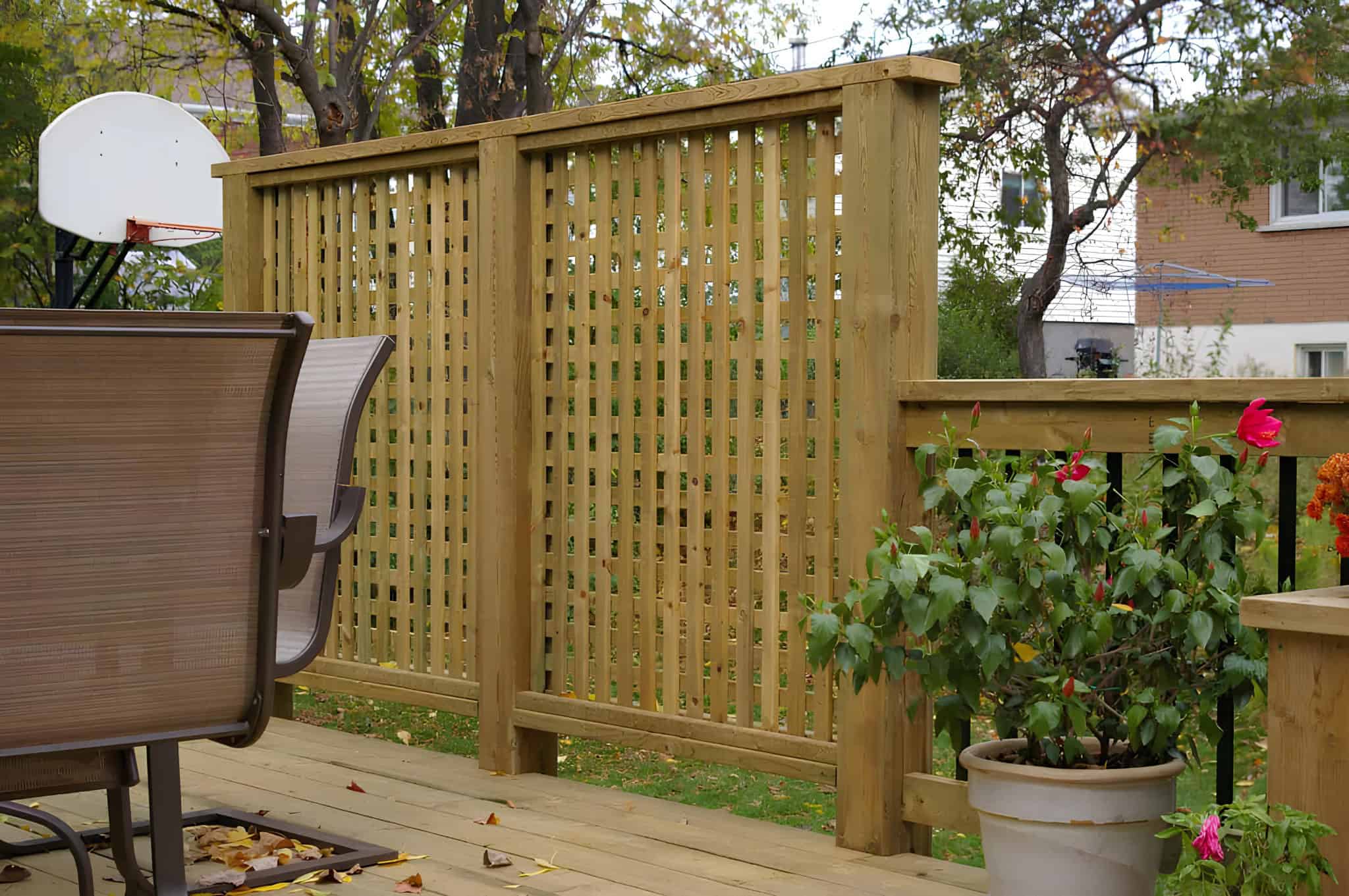 Outdoor wooden lattice privacy screen on a deck with patio furniture