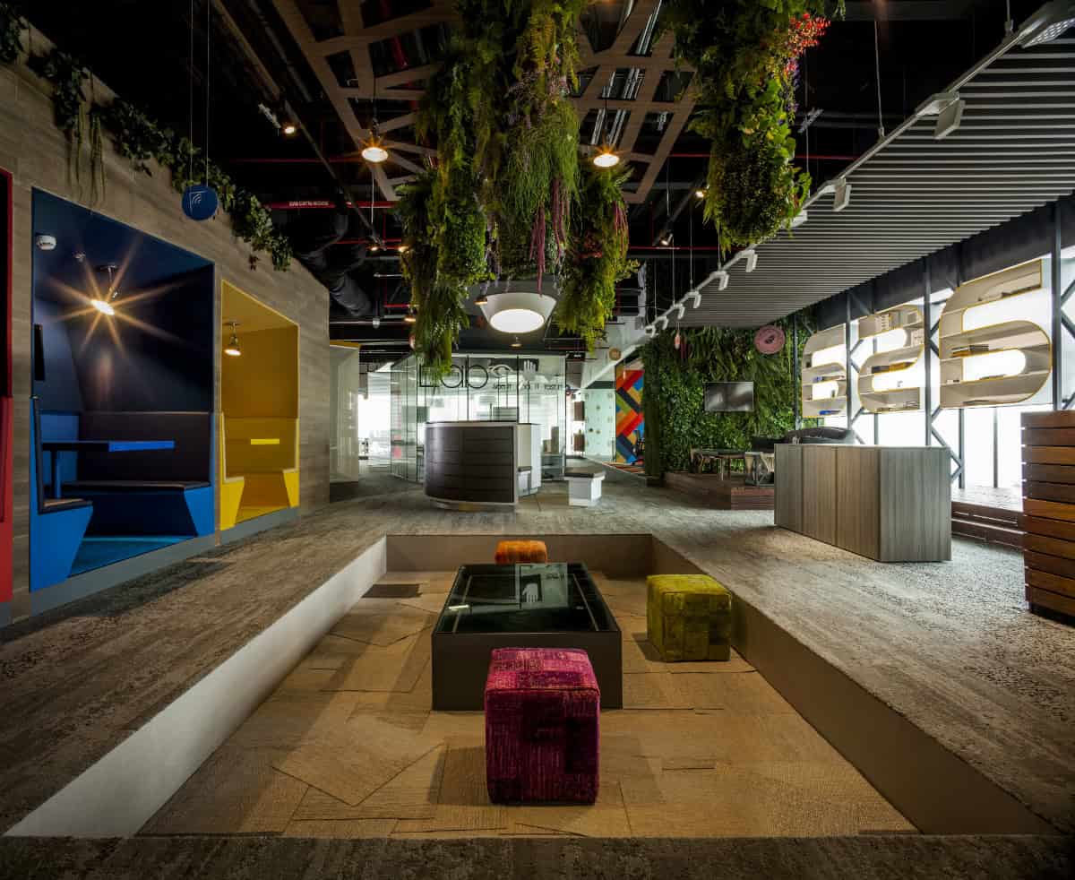 Colorful modern office lobby with innovative furniture, indoor plants, and creative lighting for trendy architectural interior design.