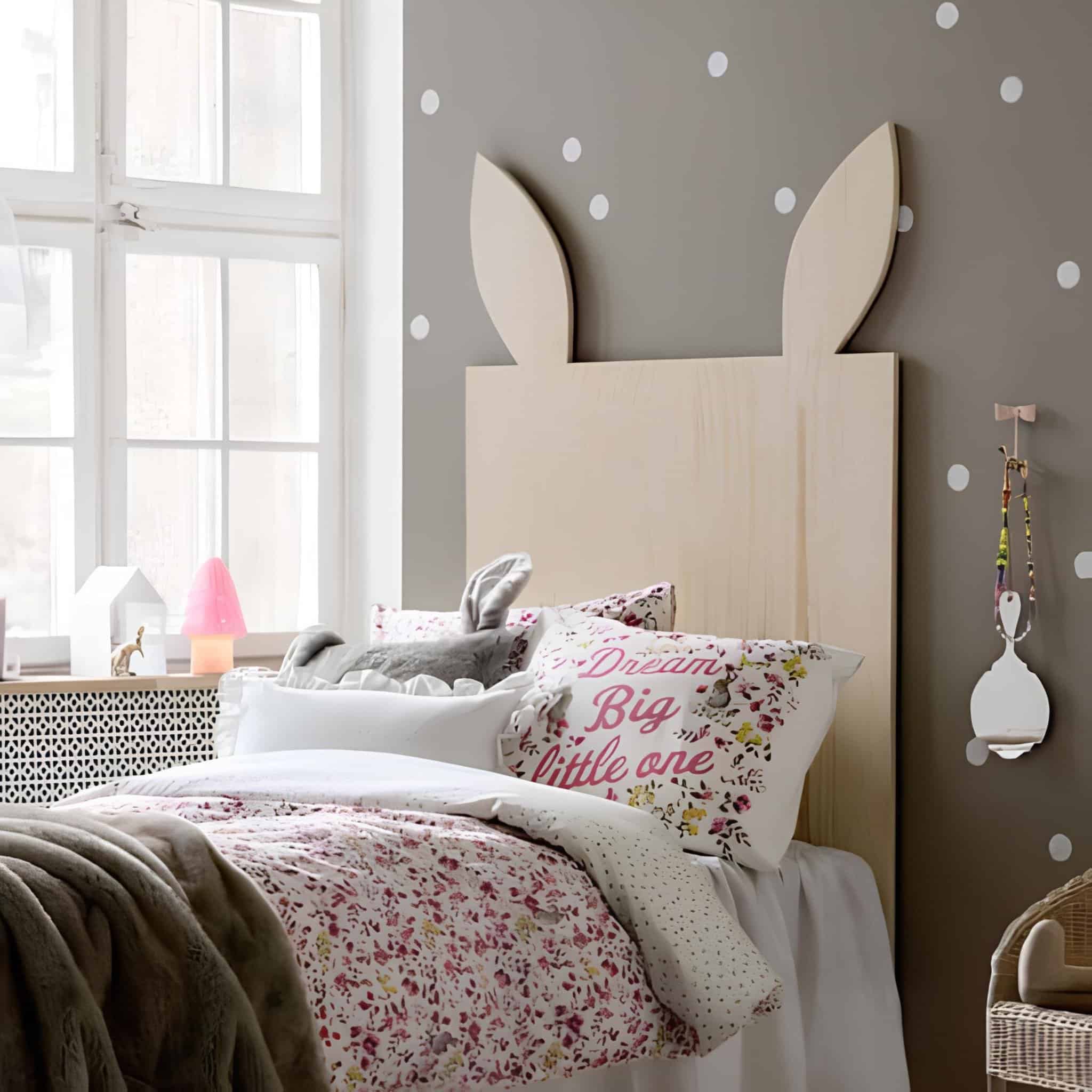 Minimal wooden headboard with bunny ears in a pastel girls' room