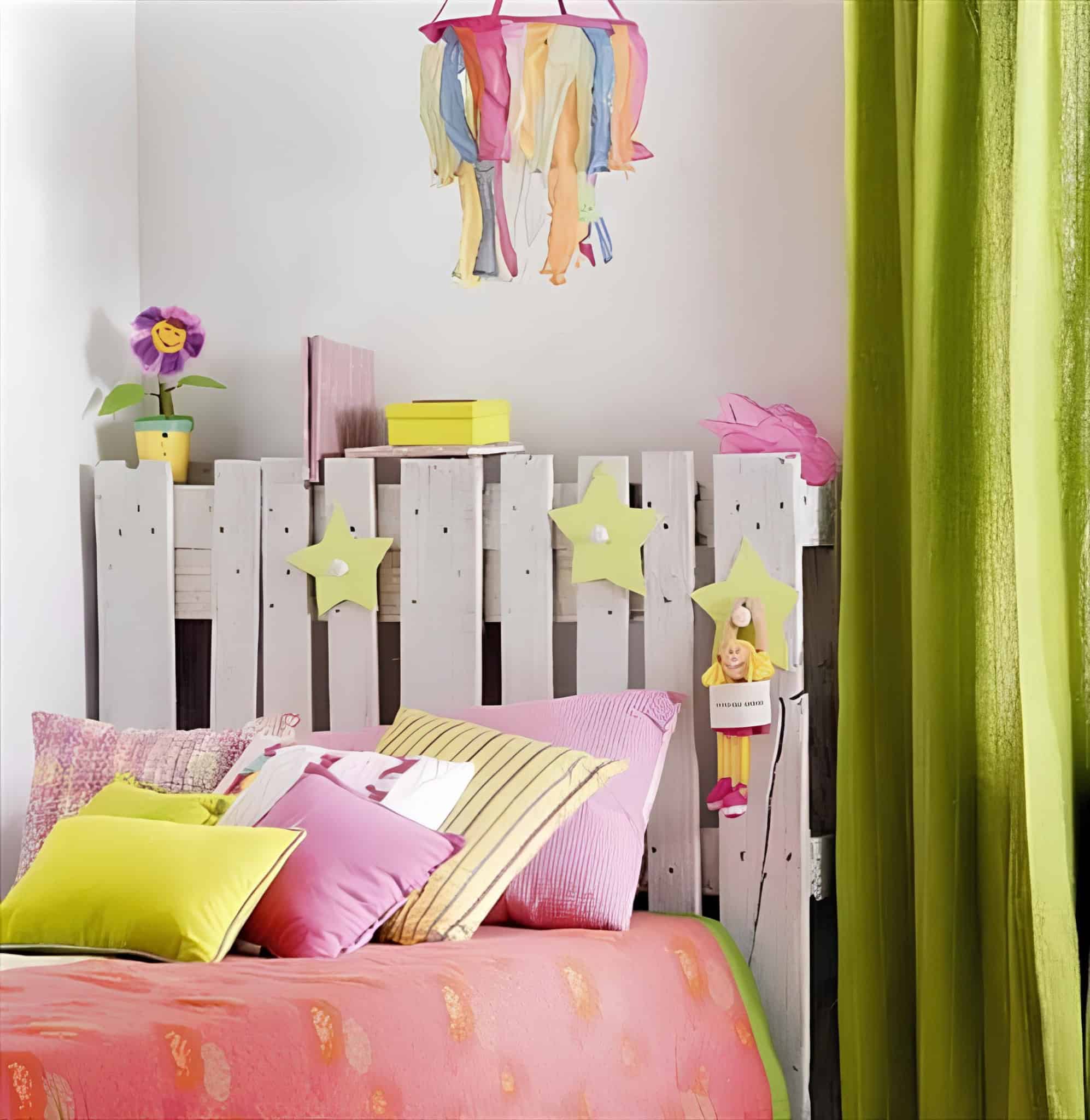 Fun and colorful children's room featuring a DIY white pallet headboard with hanging decorations and plush toys.