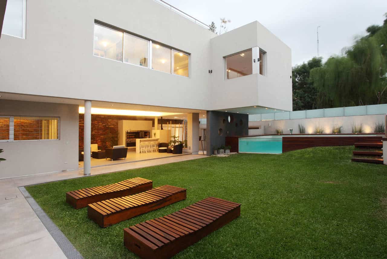 Contemporary modern house with sleek white exterior, swimming pool, lush lawn, and stylish outdoor seating, showcasing innovative architecture and elegant outdoor living design.