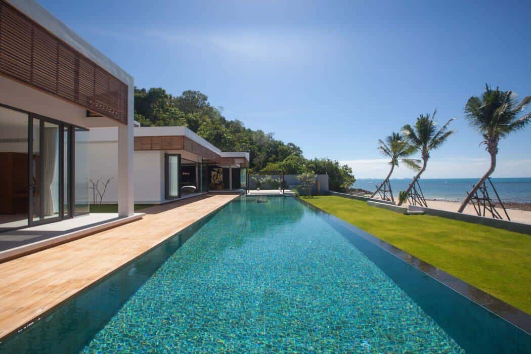 Luxury beachfront modern house with infinity pool and tropical landscaping.